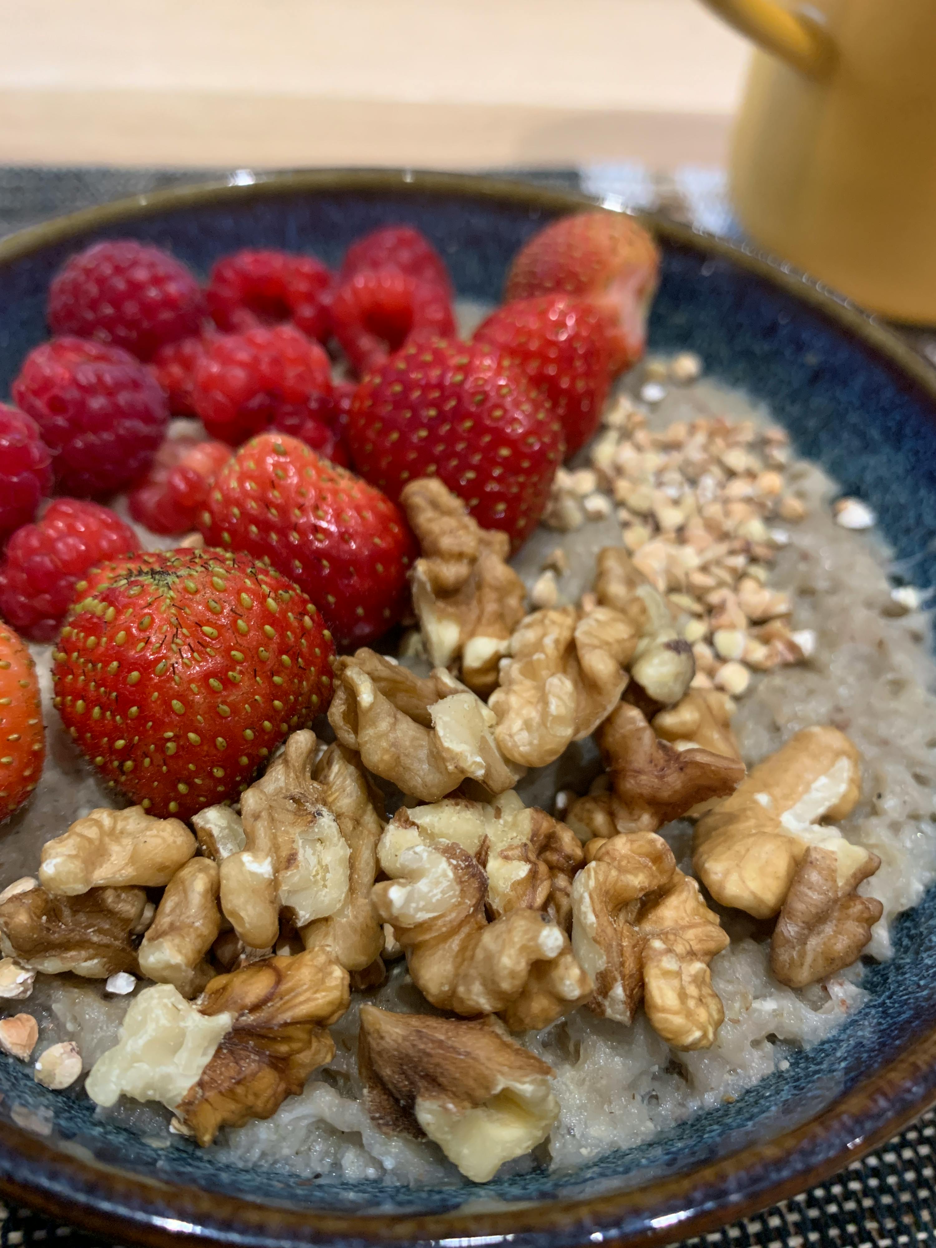 un bol d' avoine avec des fraises des framboises et des noix
