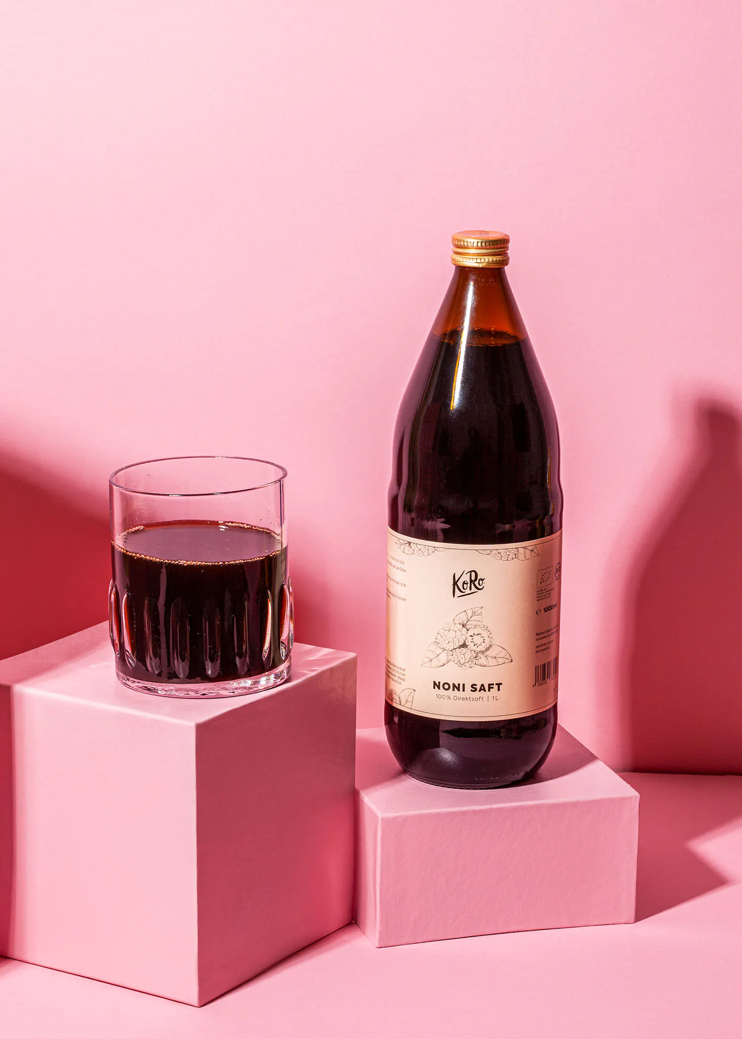 une bouteille de noni soft est assise à côté d' un verre