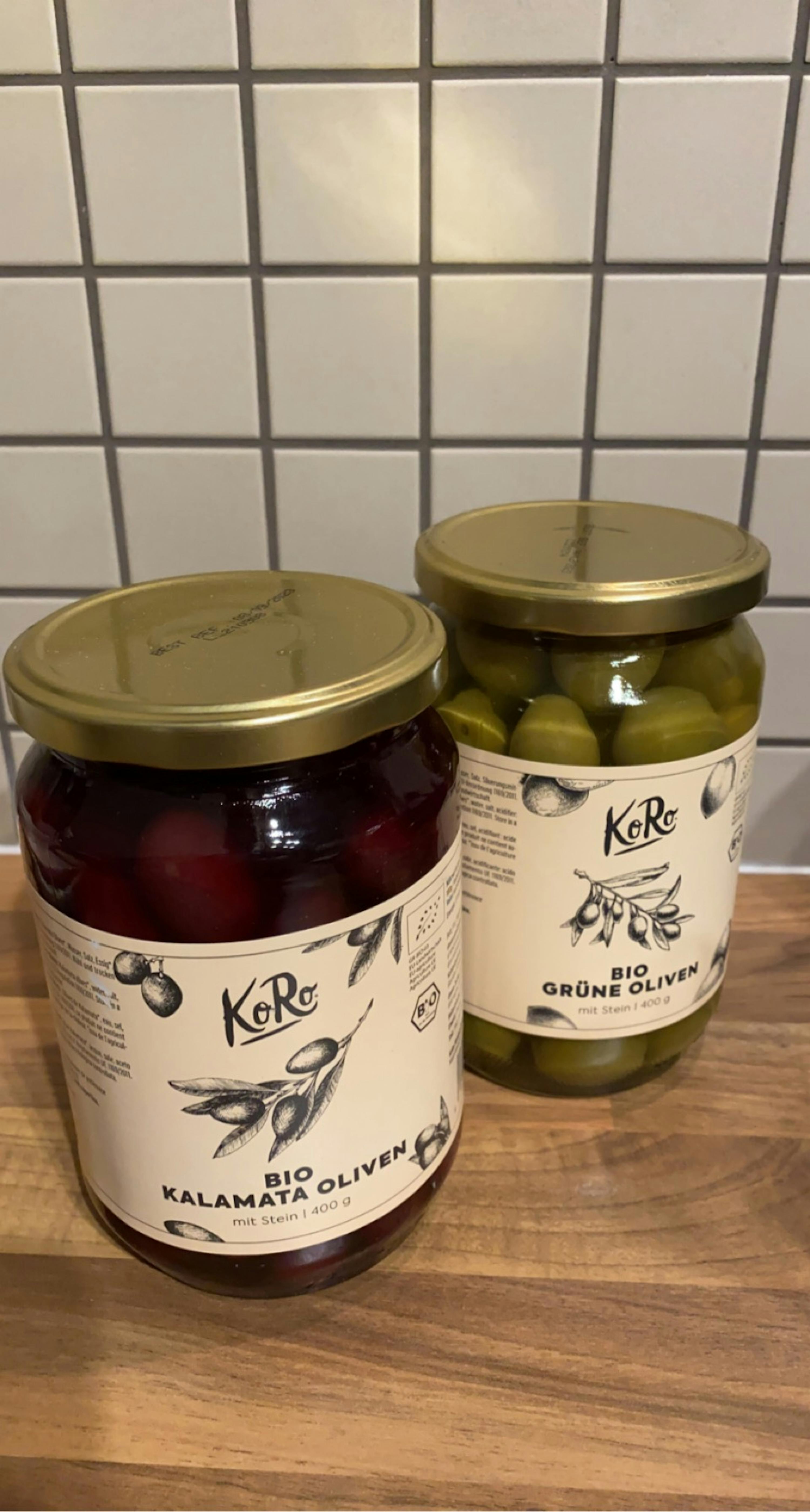 zwei Gläser mit Oliven von koro stehen nebeneinander