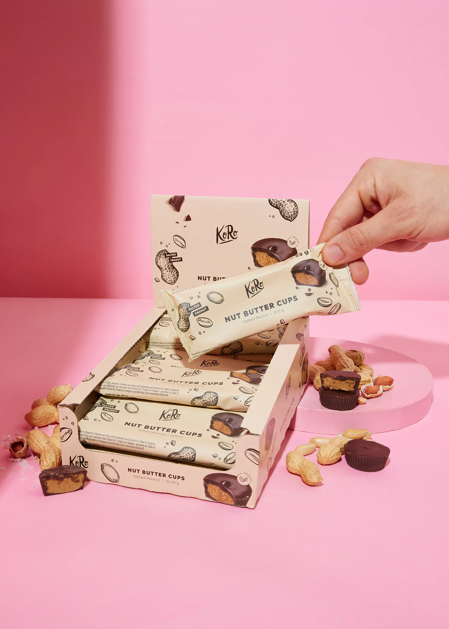 une boîte de tasses de beurre de cacahuètes avec une main tenant une tasse