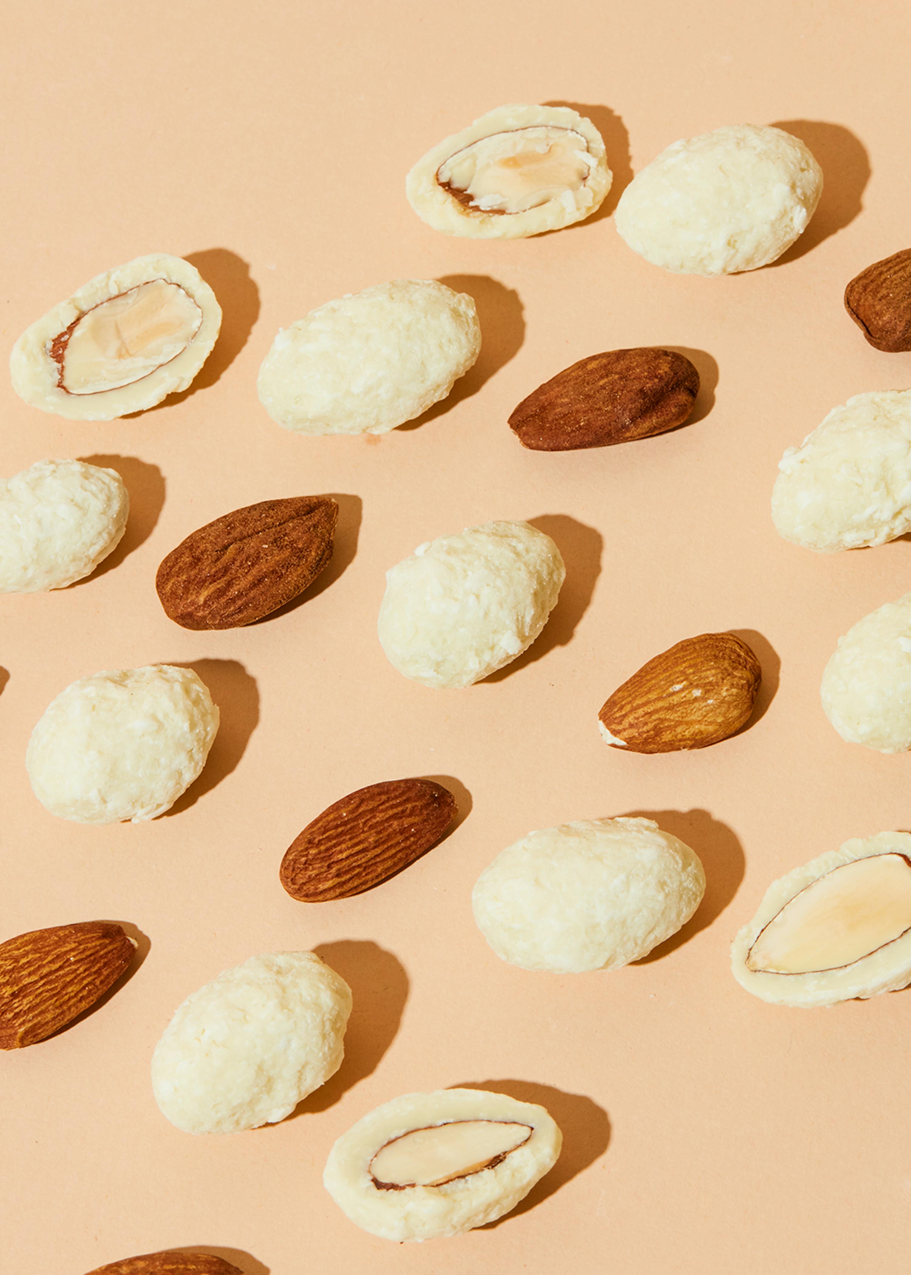 verschiedene Arten von Mandeln auf einem rosa Hintergrund