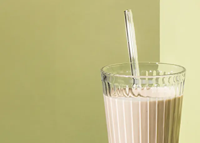 ein Milchshake mit einem Strohhalm in einem Glas