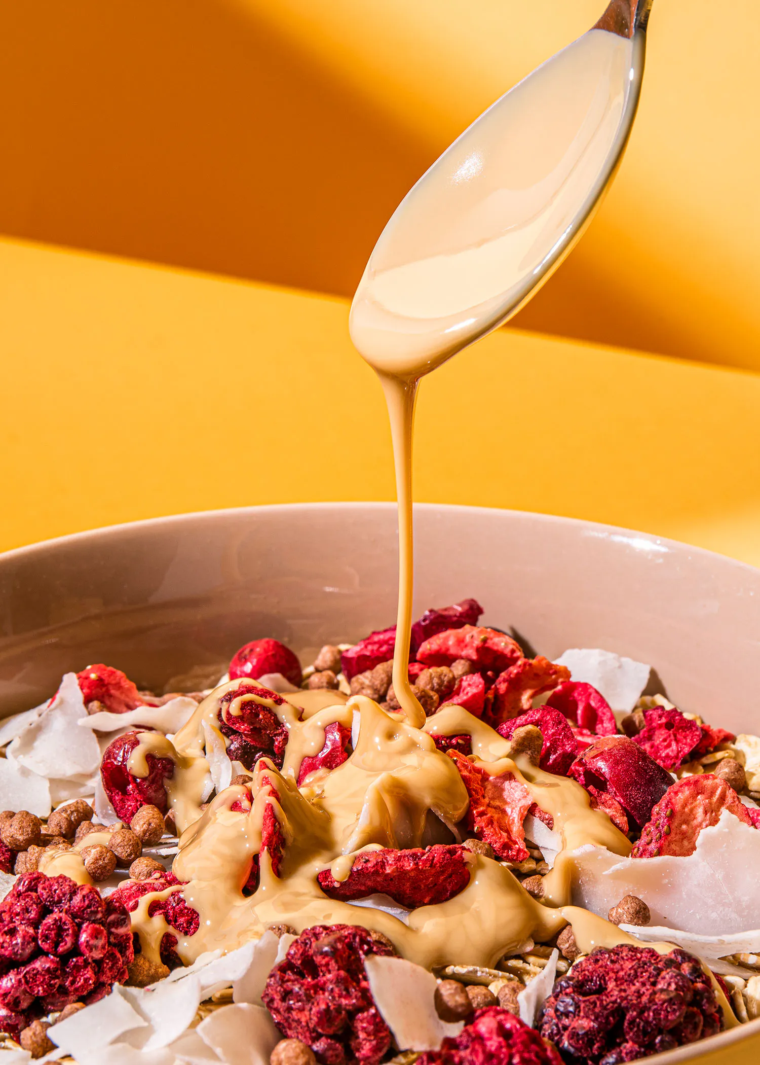 eine Schüssel Müsli mit Erdnussbutter und getrockneten Früchten wird mit einem Löffel gefüllt
