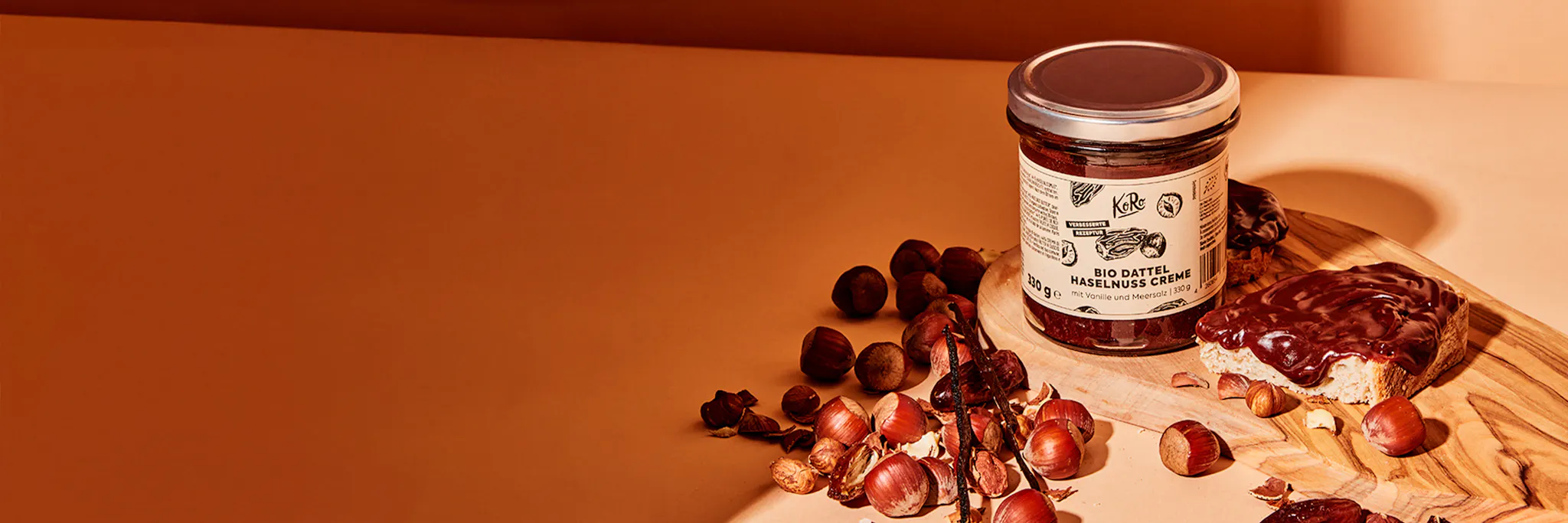 a jar of bio dattel hazelnuss creme sits on a wooden cutting board