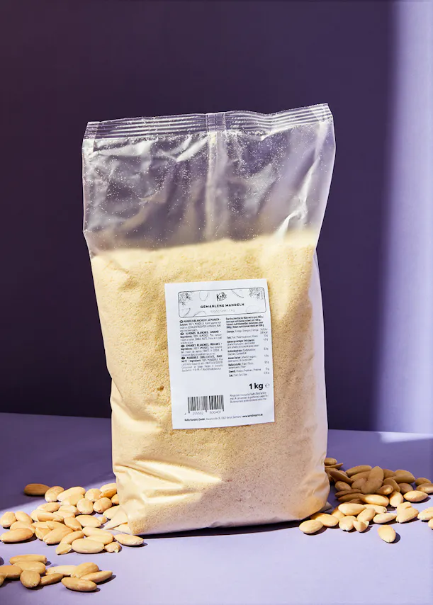 un sac de farine d' amandes est assis sur une table entourée d' amandes