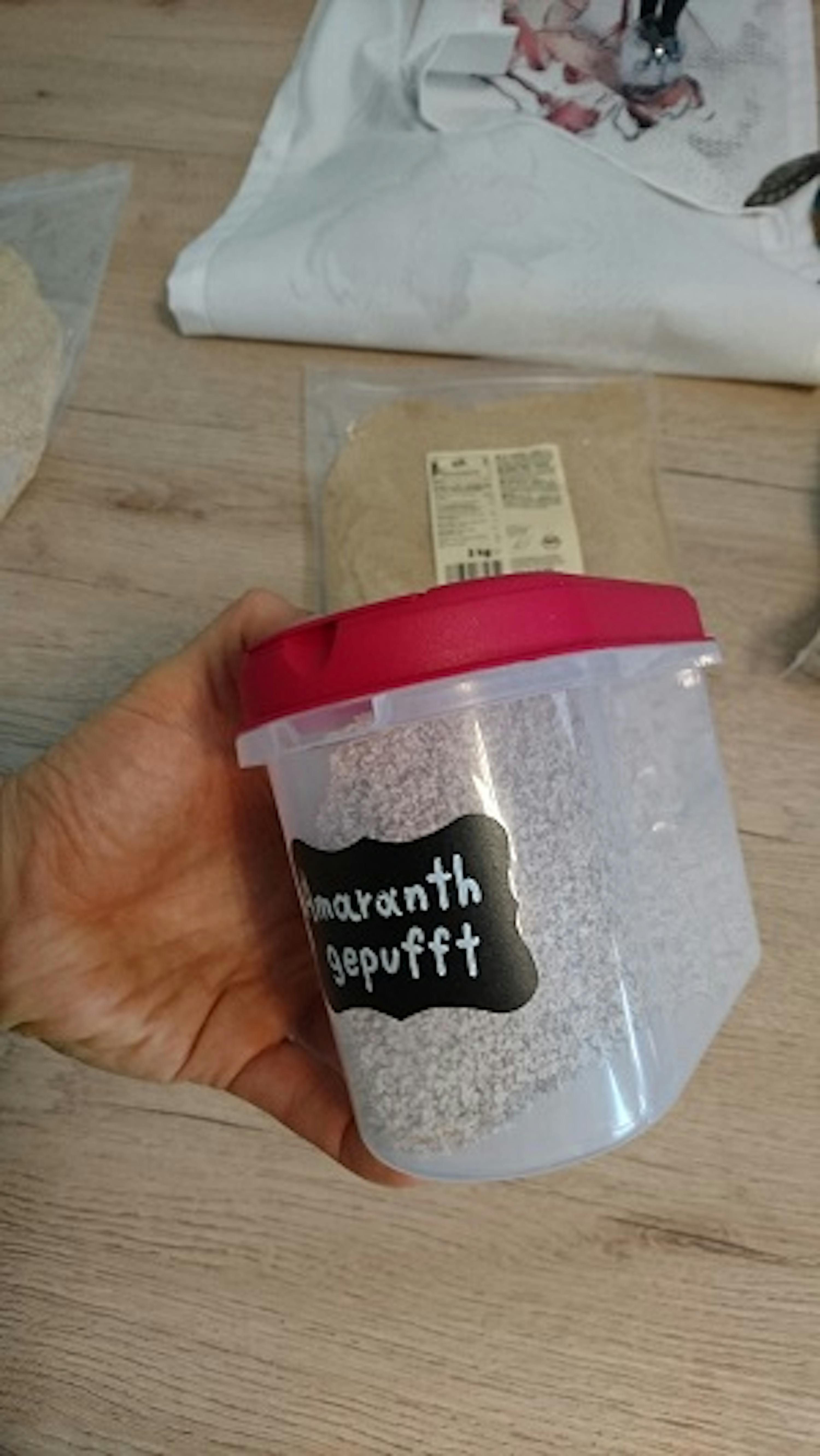 eine Person hält einen Plastikbehälter mit einem Aufkleber darauf .