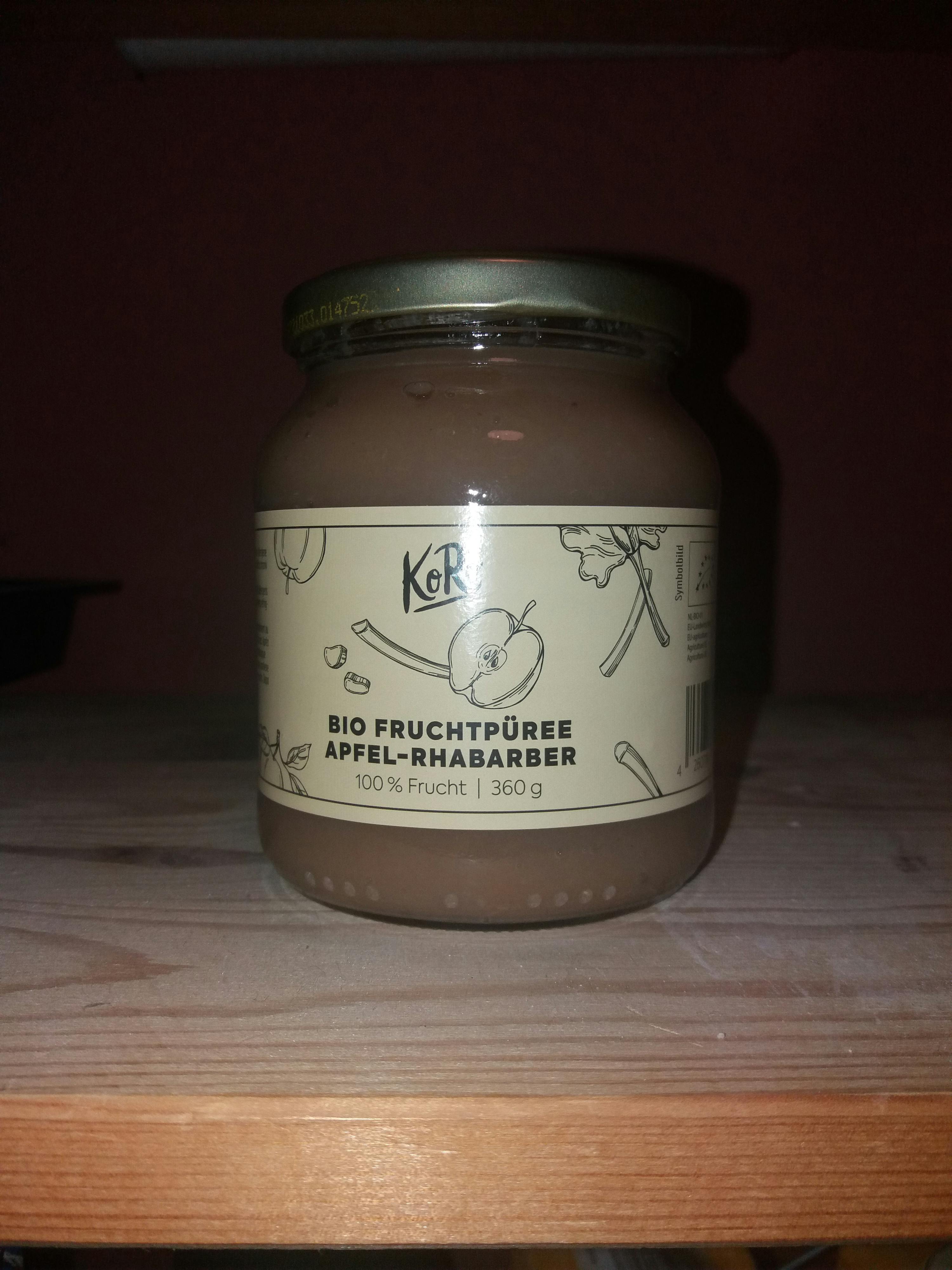 un barattolo di purè di frutta è seduto su un tavolo di legno