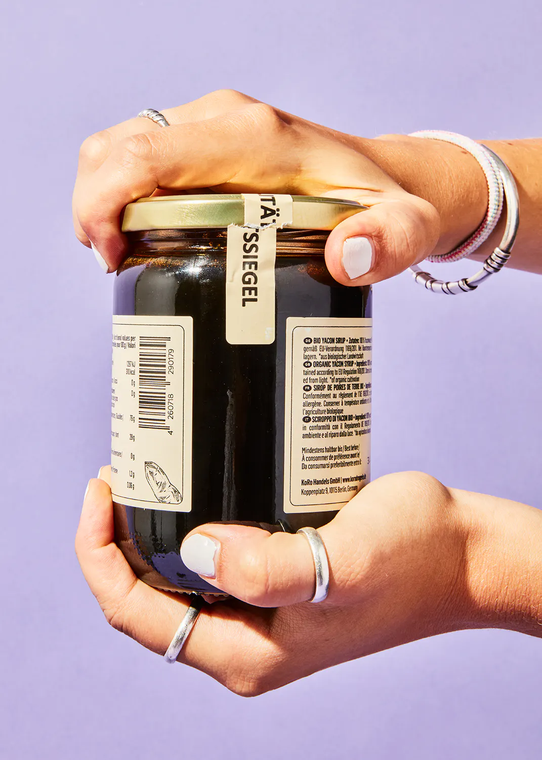 a person is holding a jar with a label that says ' ta ' ssiegel ' on it