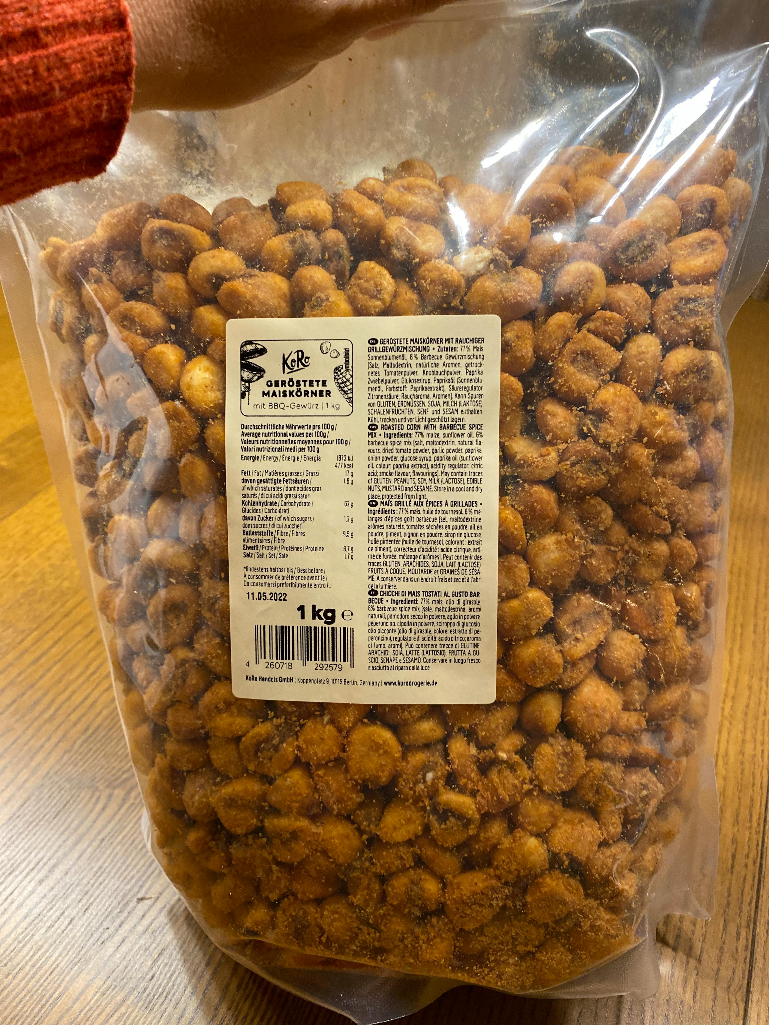 une personne tient un sac de cacahuètes avec une étiquette de 1 kg