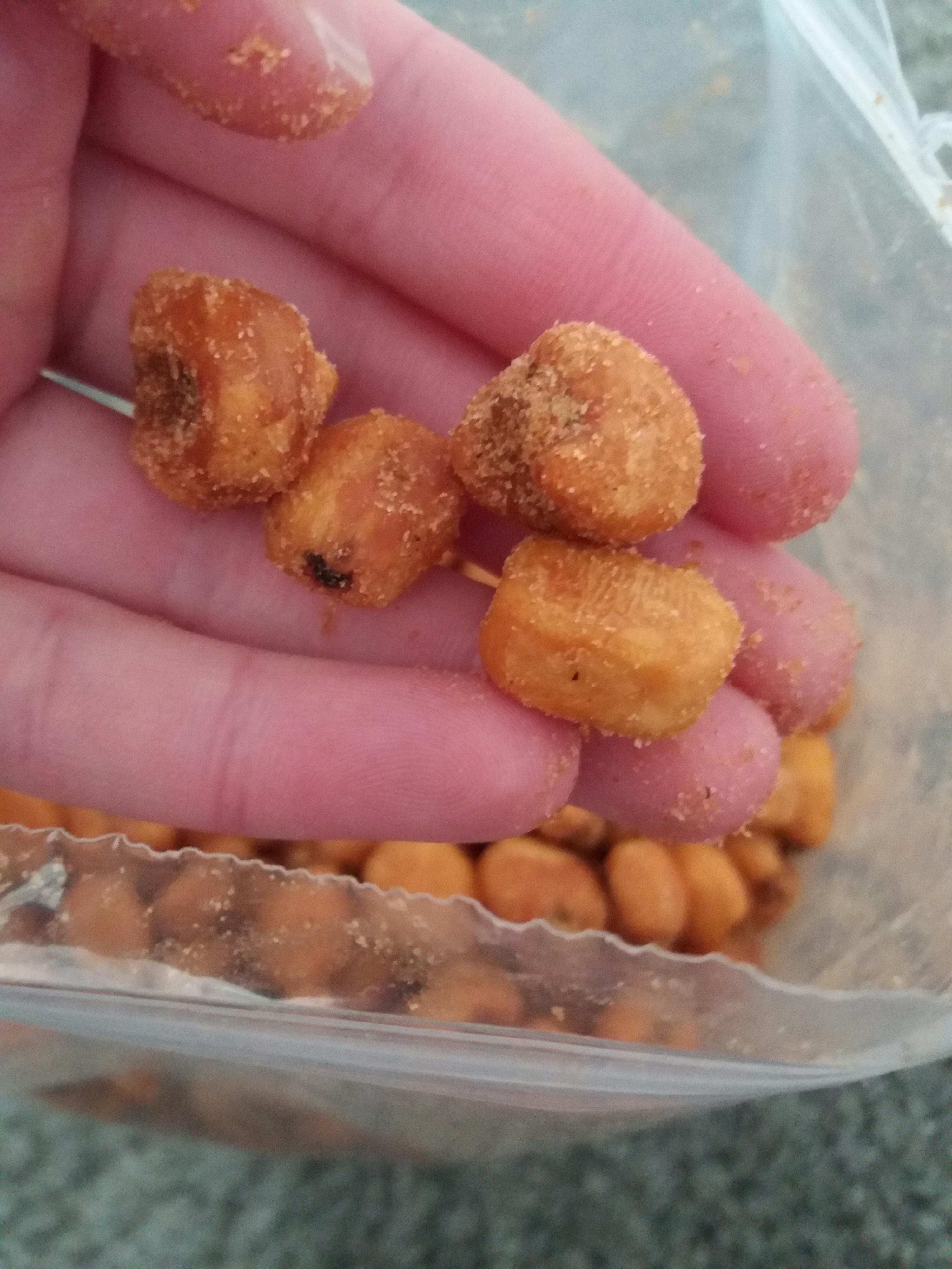 une personne tient un tas de maïs frit dans sa main