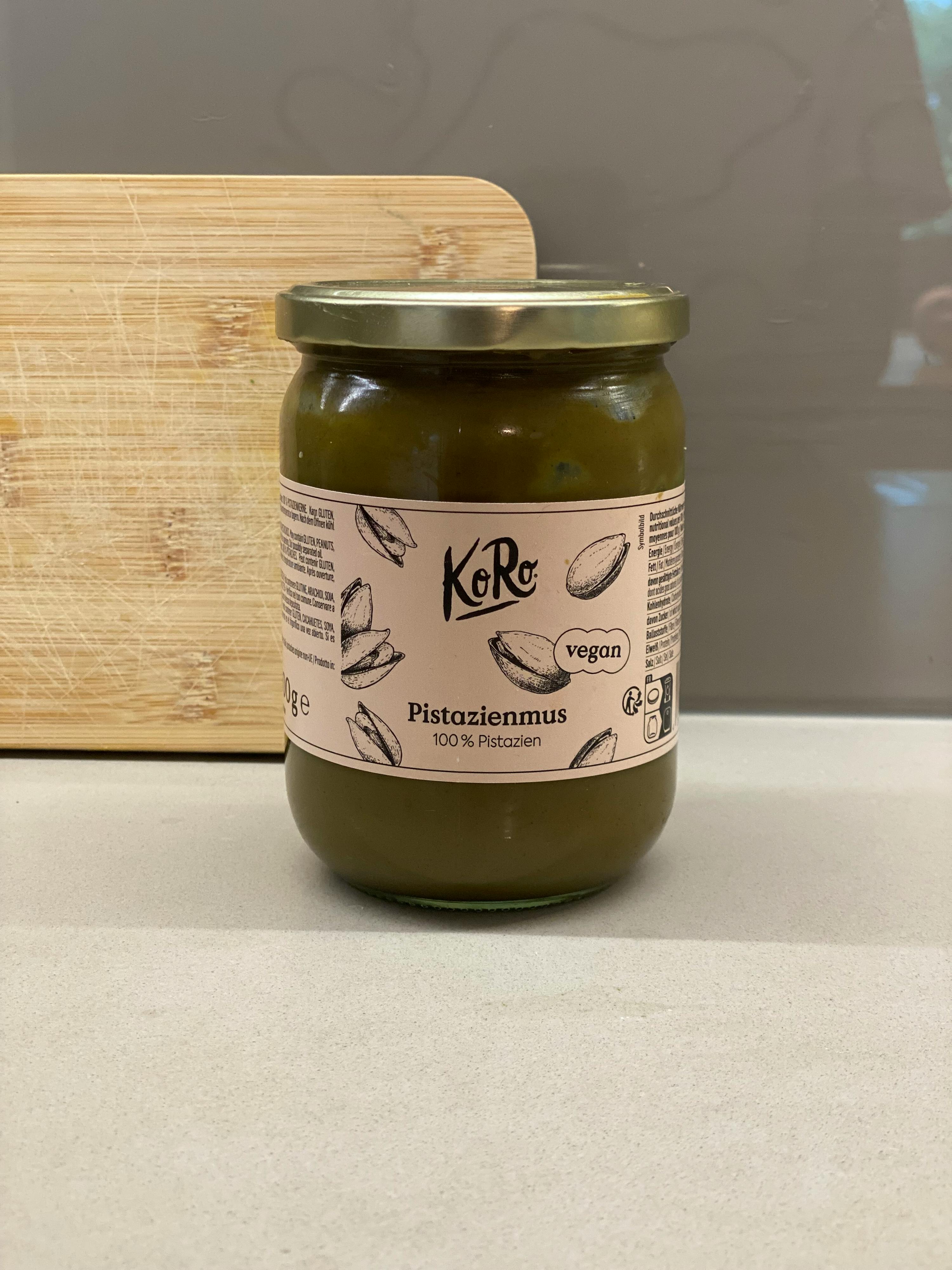 un bocal de pesto de pistache est posé sur une planche à découper en bois
