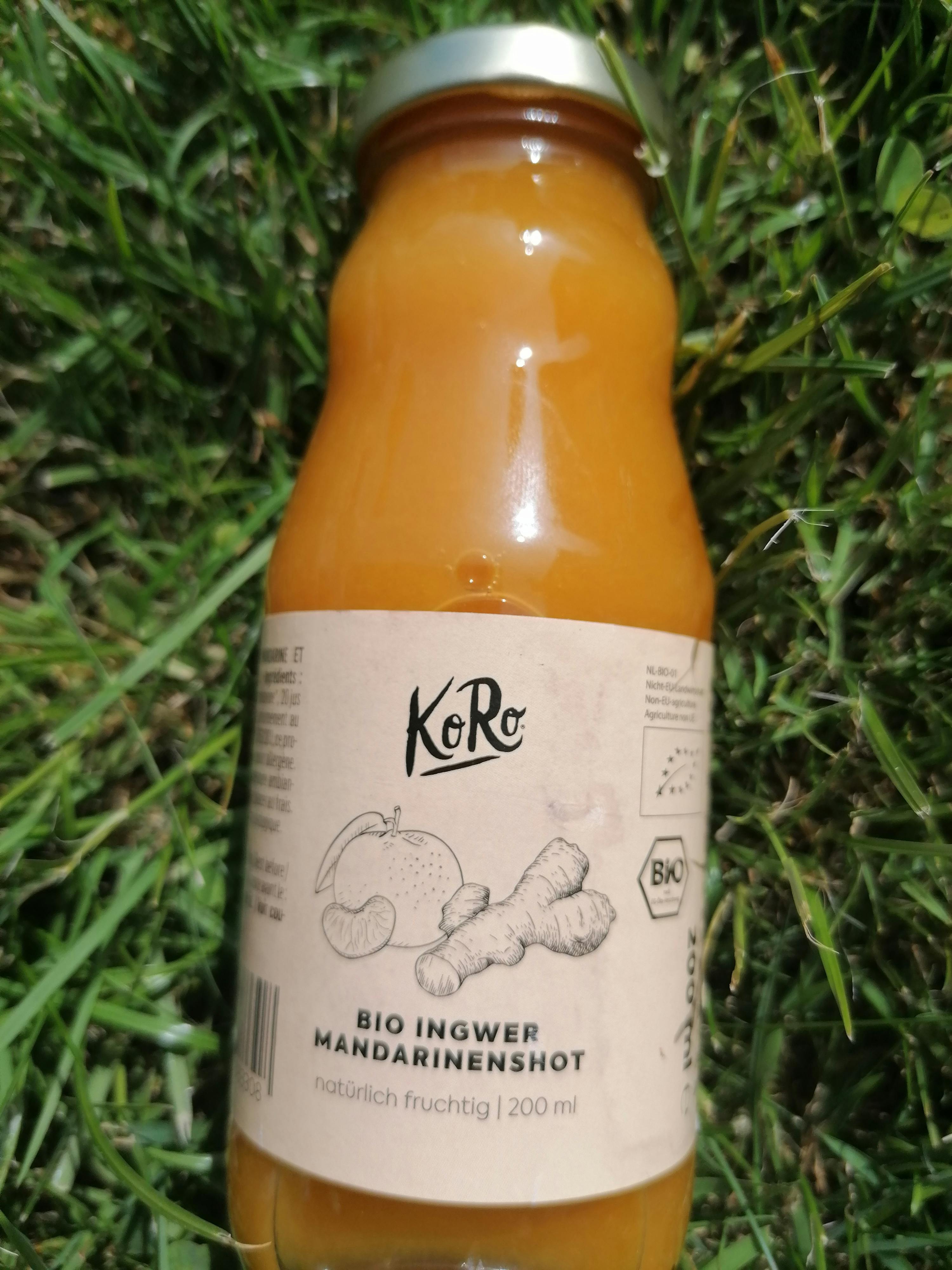 une bouteille de korc bio ingwer mandarinenshot est assise dans l' herbe