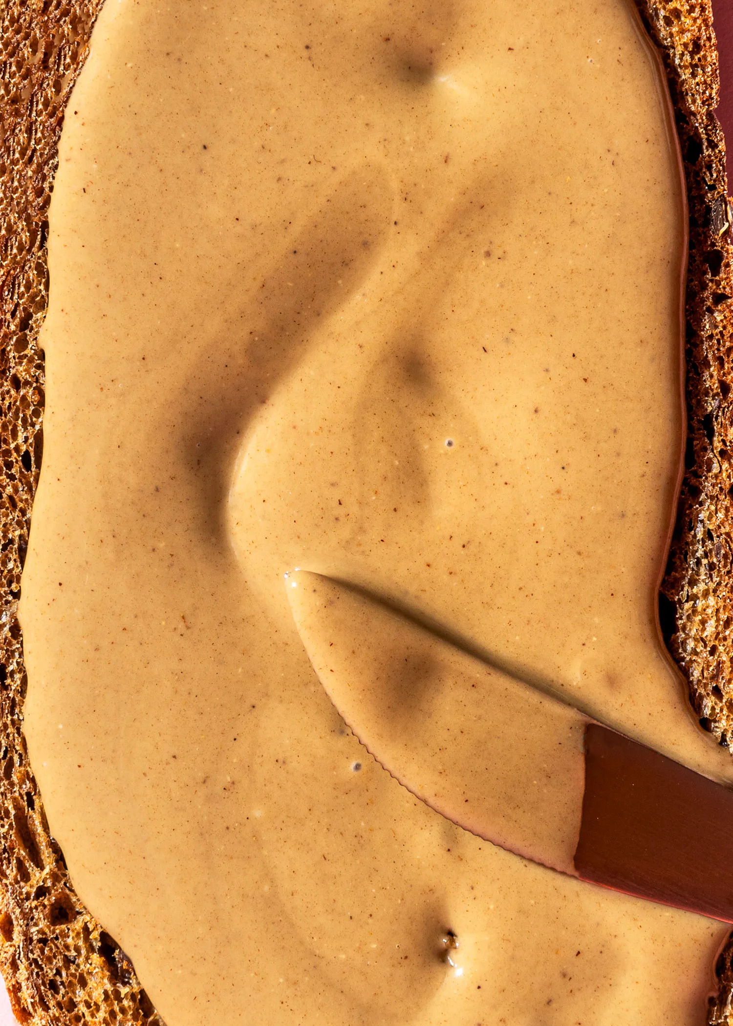 une tranche de pain est recouverte de beurre d' arachide