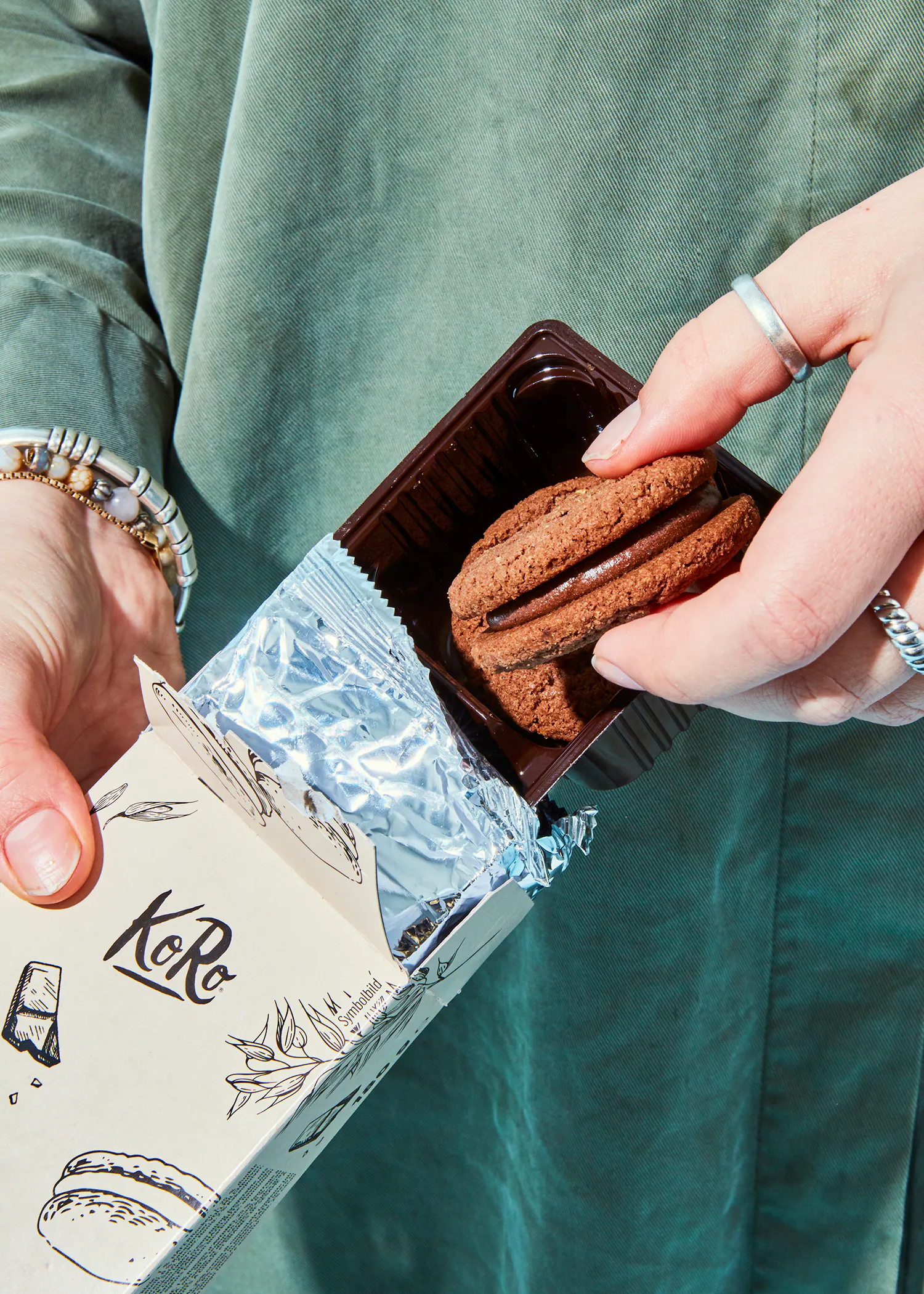 une personne tient une boîte de biscuits à la main