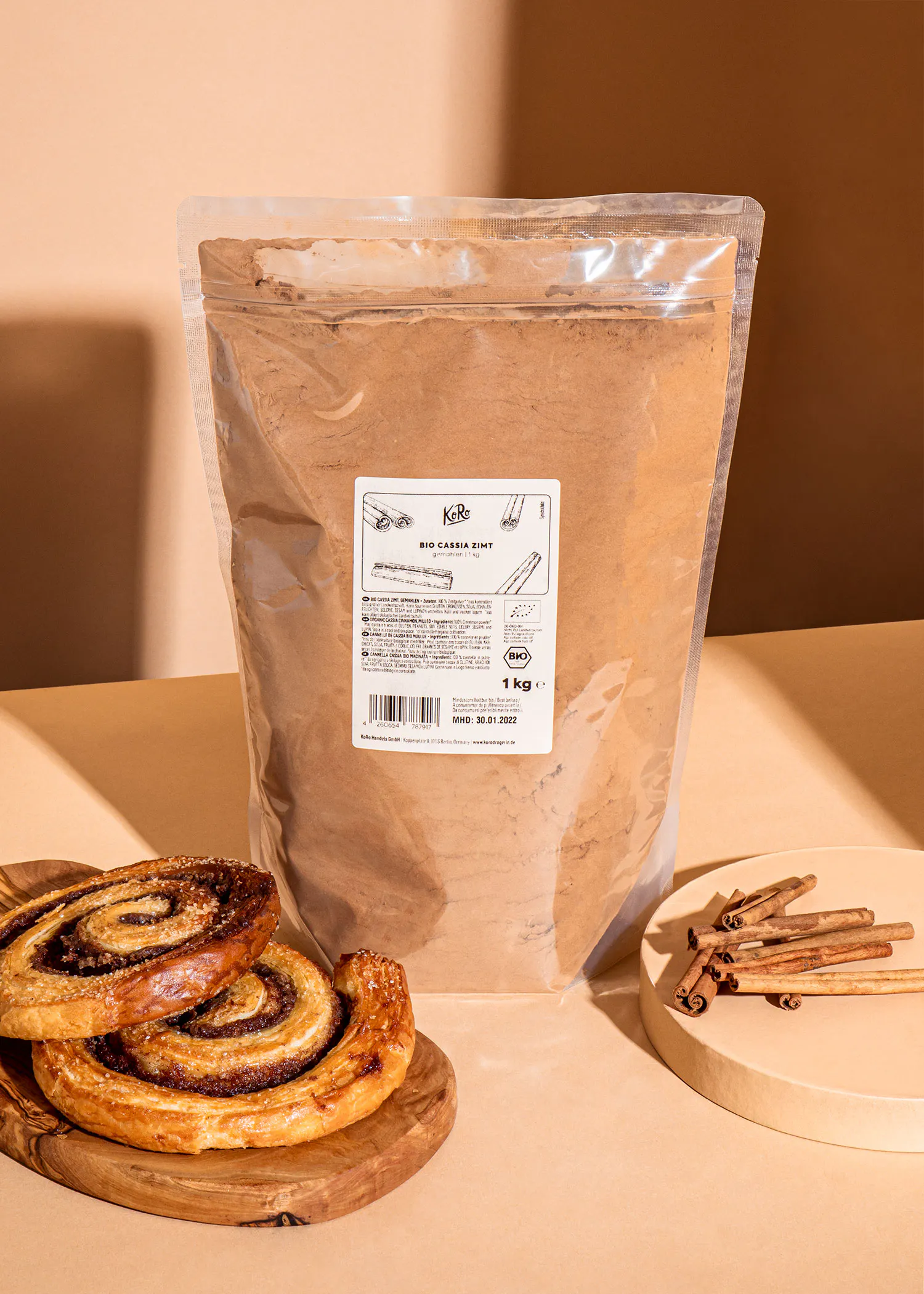 un sac de poudre de cannelle est posé sur une table à côté d' un rouleau de pâtisserie