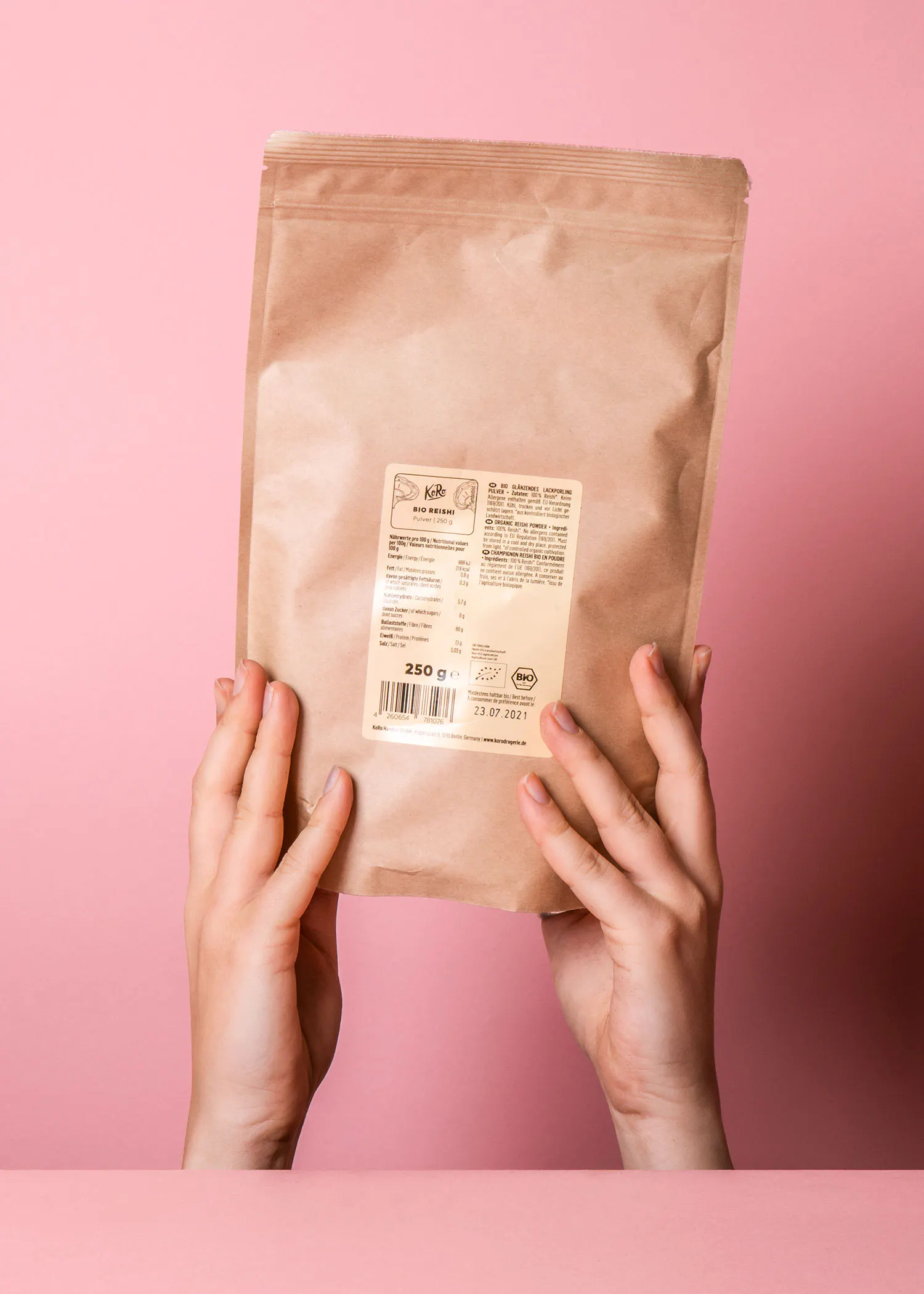 une personne tient un sac en papier brun avec une étiquette blanche sur le dos