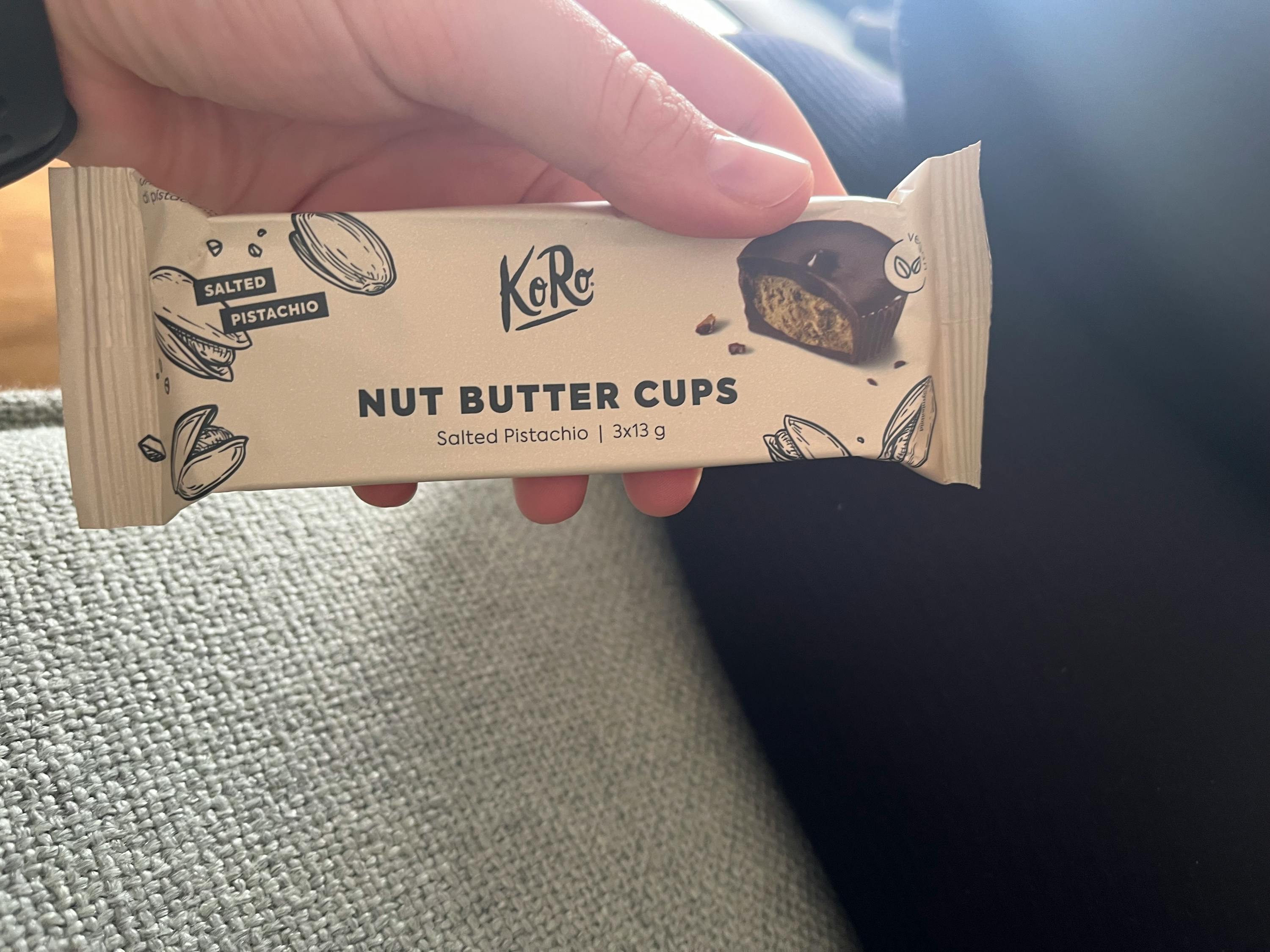 une personne tient un paquet de tasses au beurre de noix