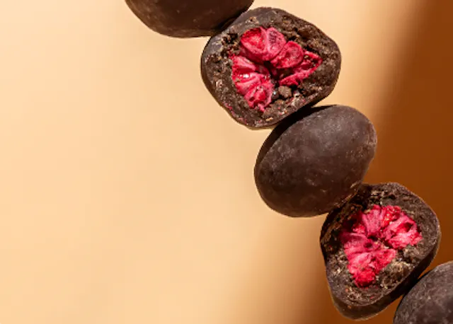 a row of chocolate covered berries with a pink center