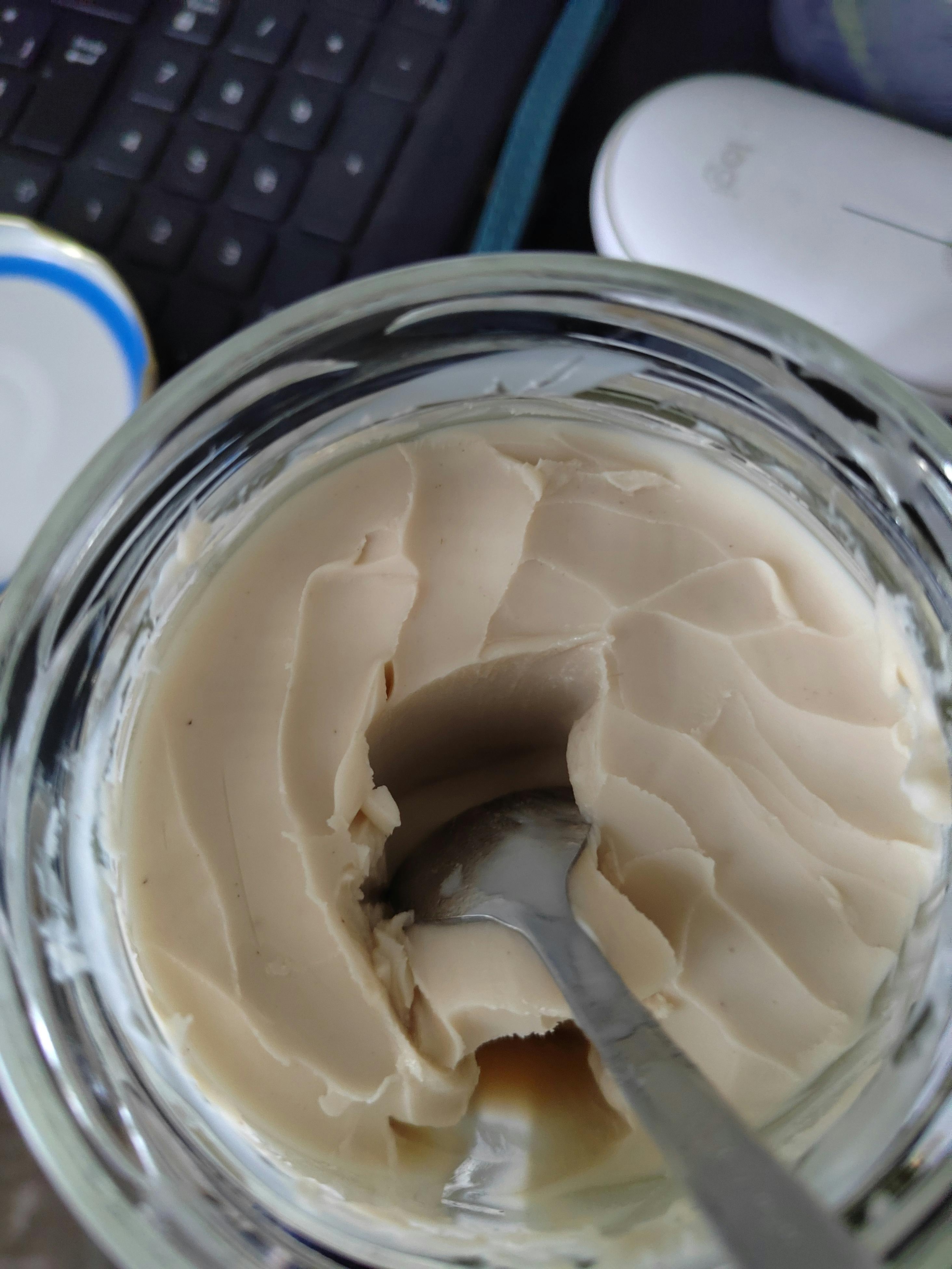 a jar of peanut butter has a spoon in it