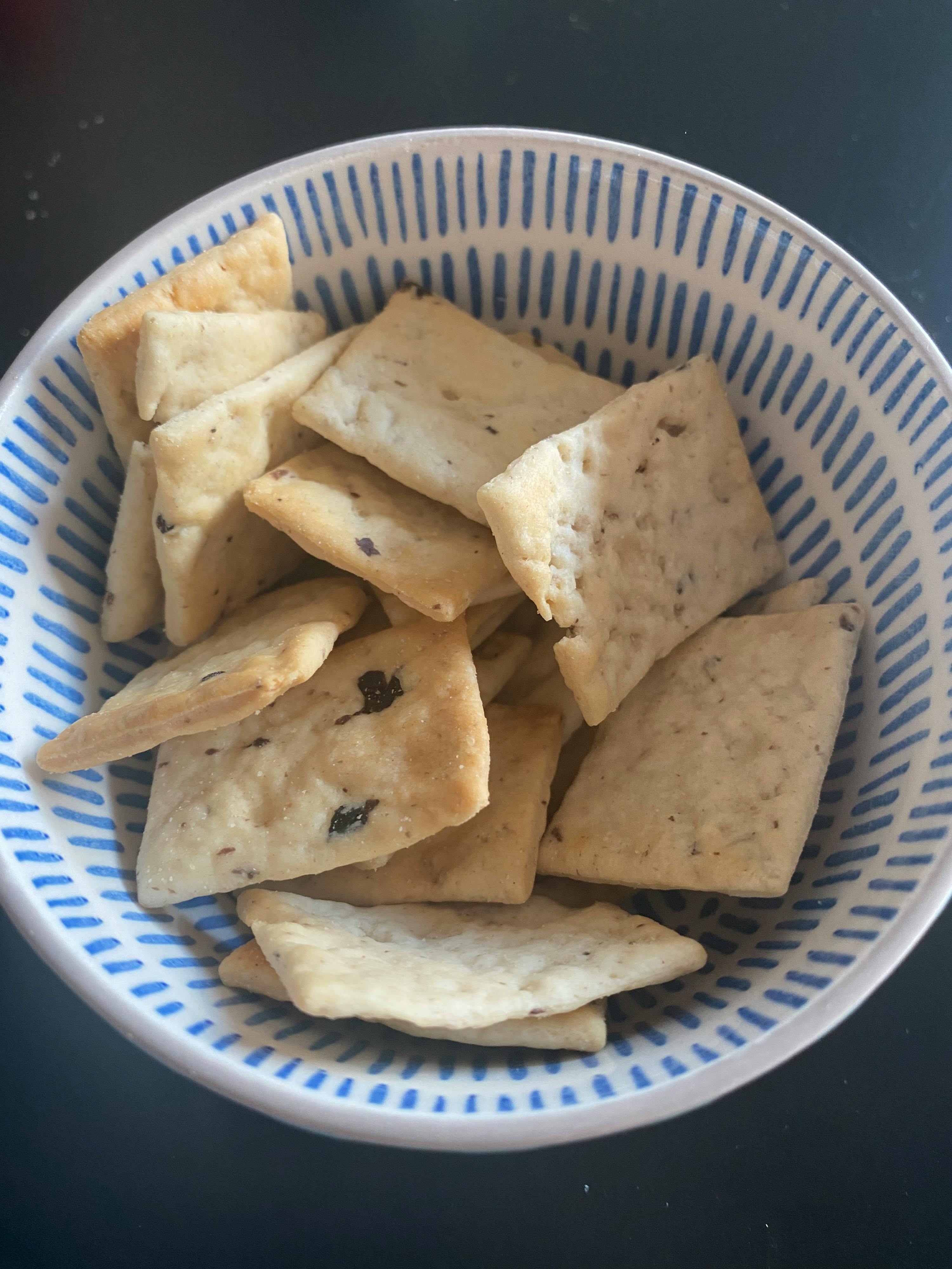 a blue and white bowl filled with crackers with raisins