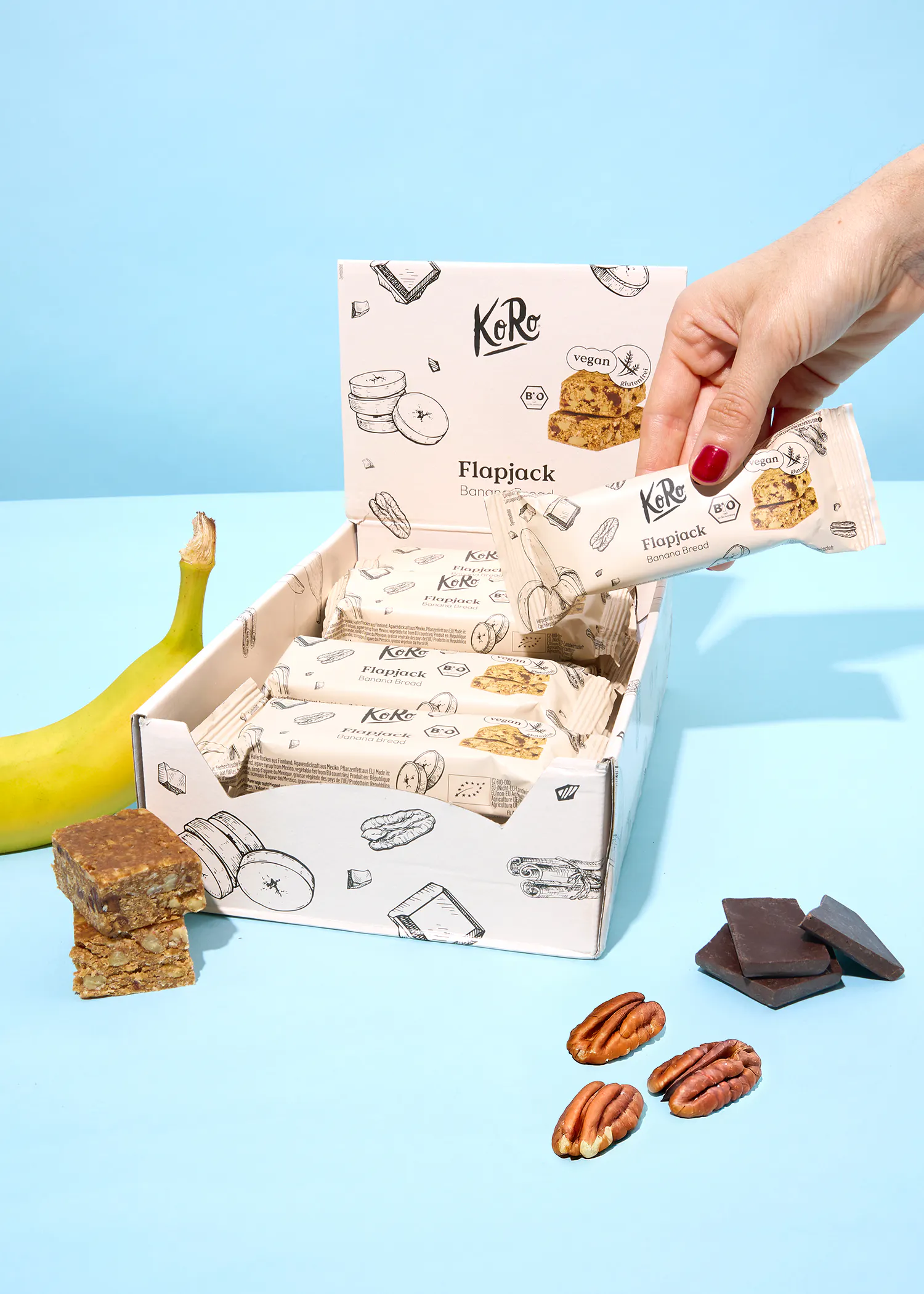 eine Person nimmt eine Bananenflippack-Bar aus einer Schachtel