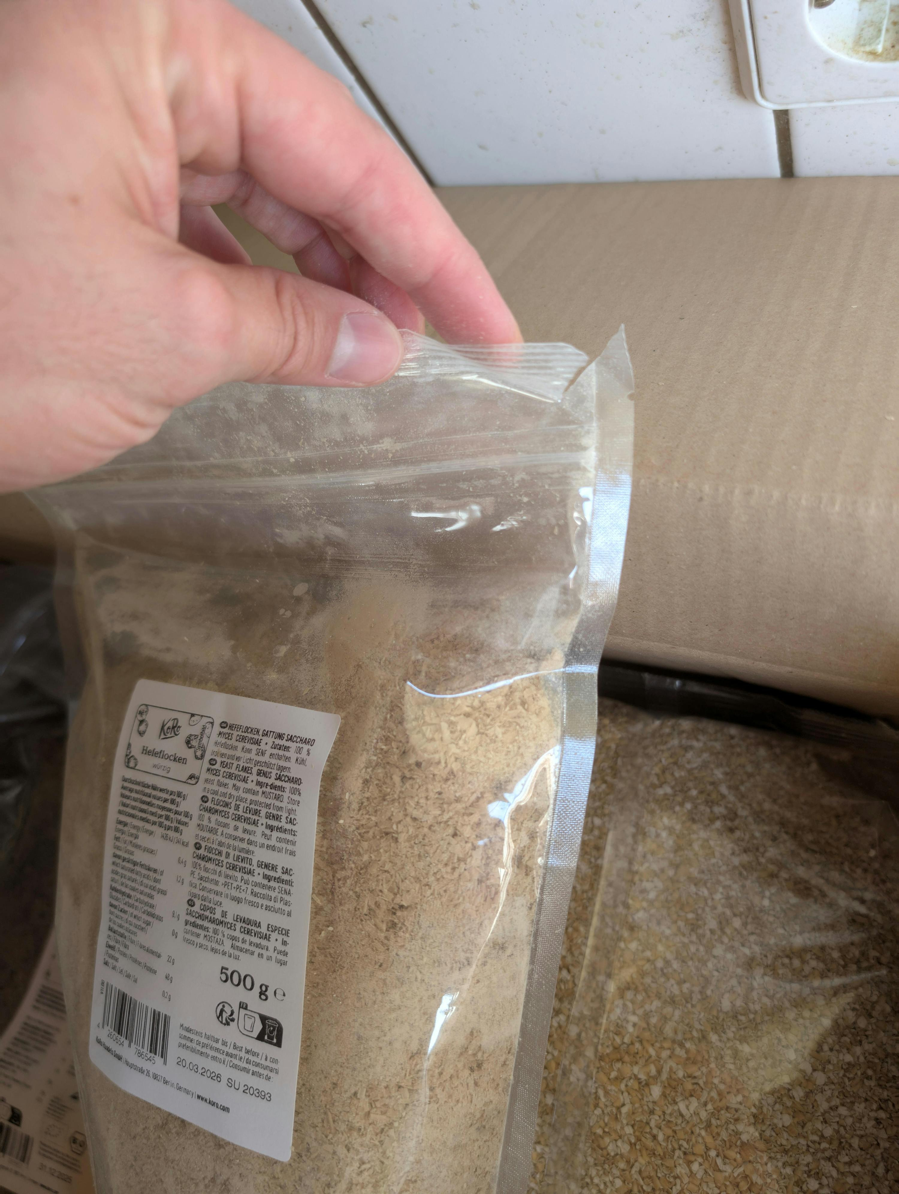 eine Person öffnet einen Plastikbeutel mit einem Etikett auf der Rückseite