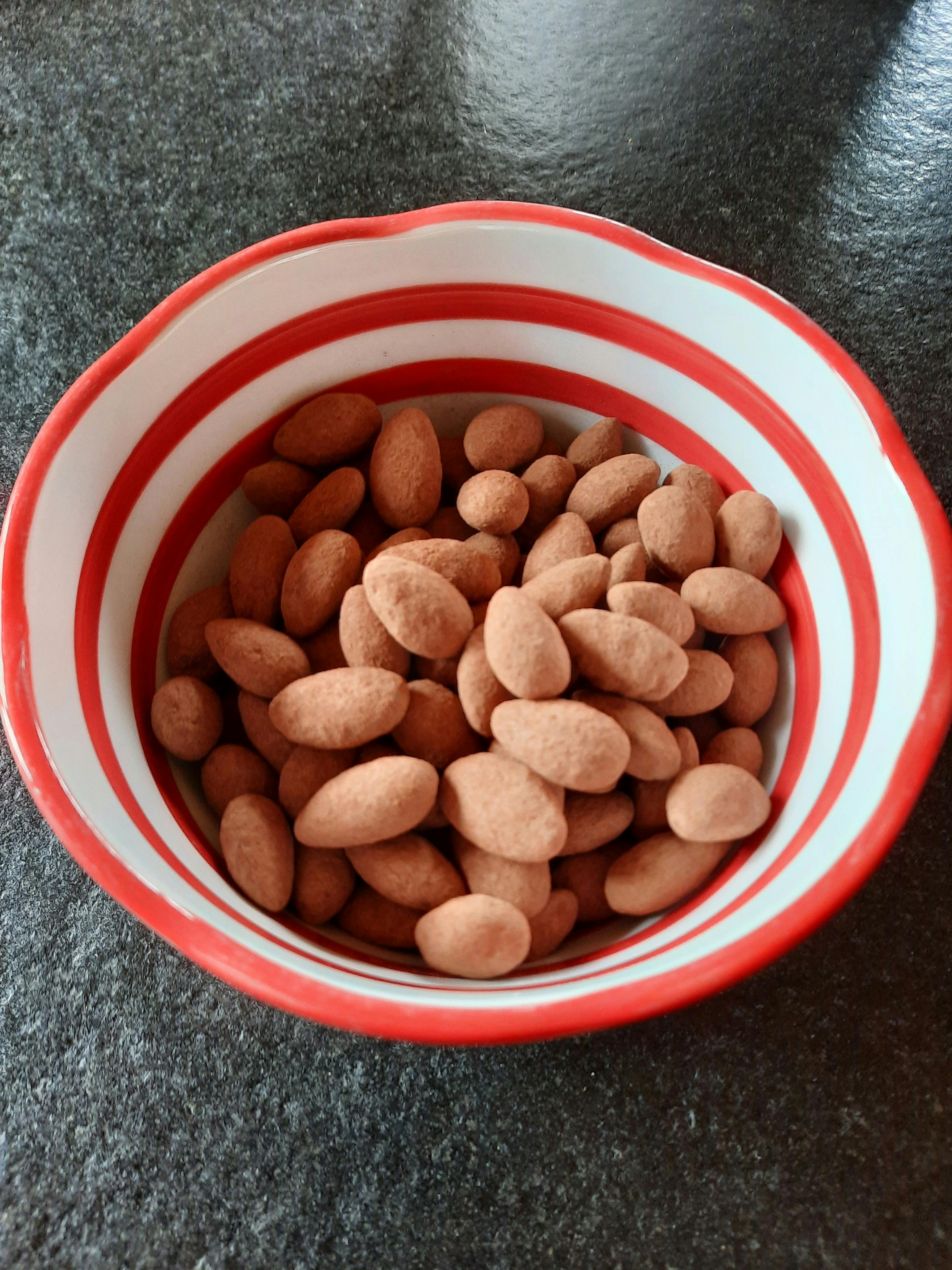 eine rote und weiß gestreifte Schüssel gefüllt mit Erdnüssen
