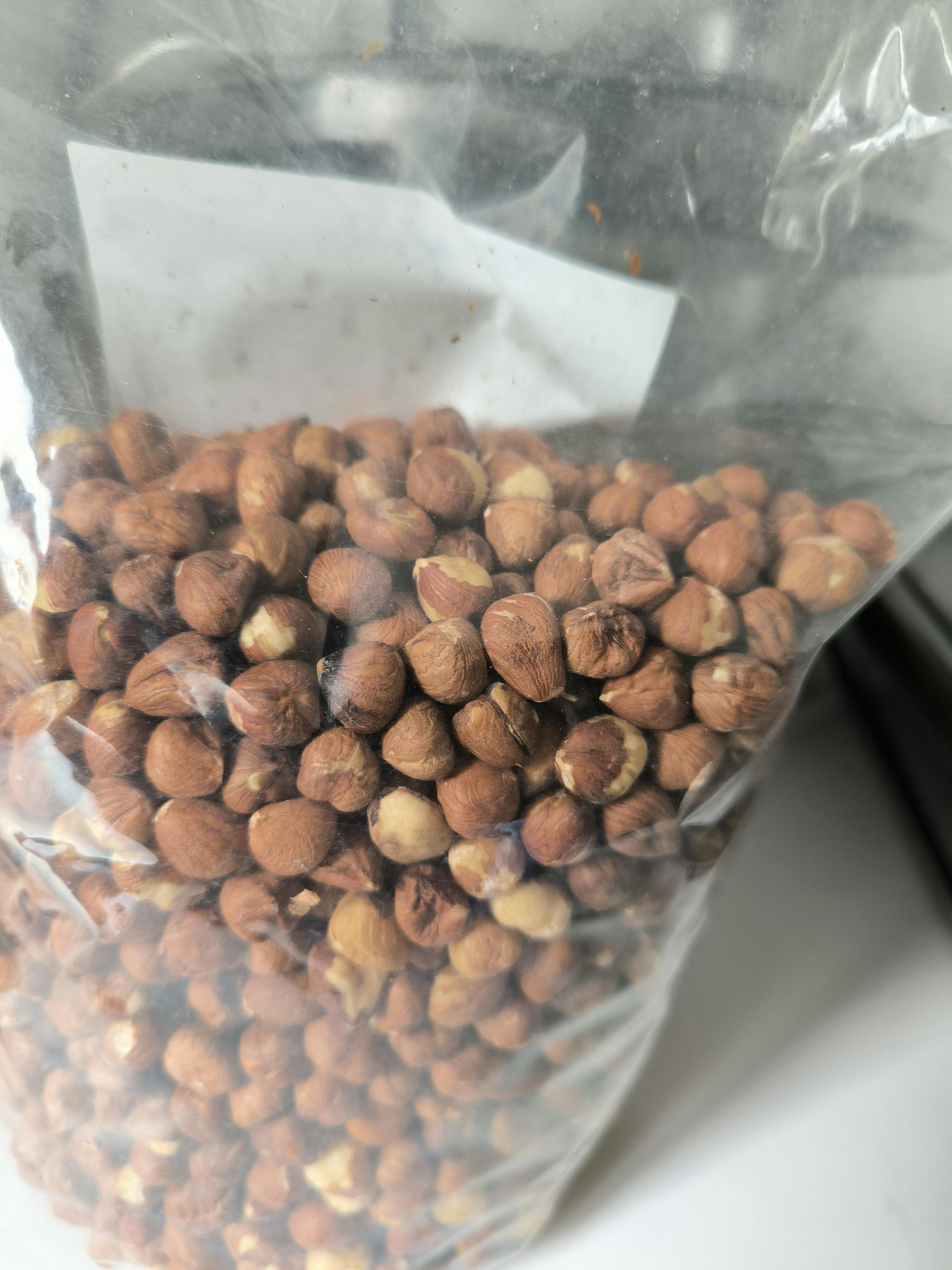 nocciole sgusciate in un sacchetto di plastica trasparente.