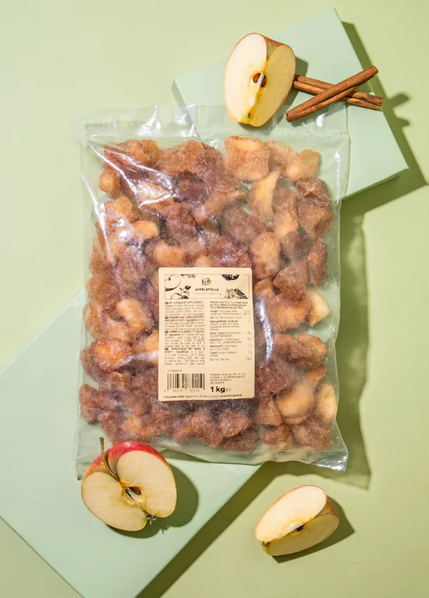 un sac de pommes frites est assis sur une table avec des pommes et des bâtons de cannelle