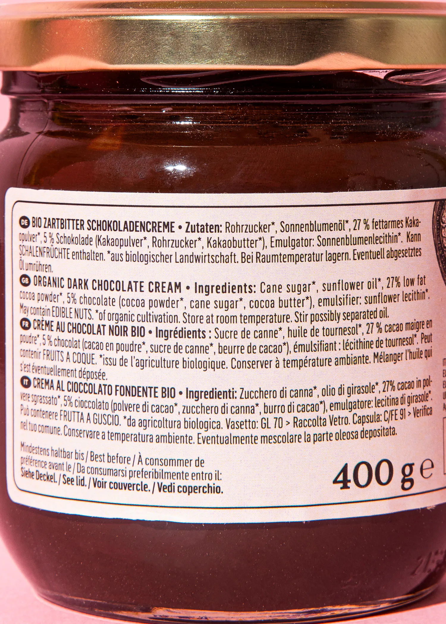 ein glas dunkle schokoladencreme mit einem etikett, das zutateninformationen in mehreren sprachen und das gewicht von 400 gramm zeigt.