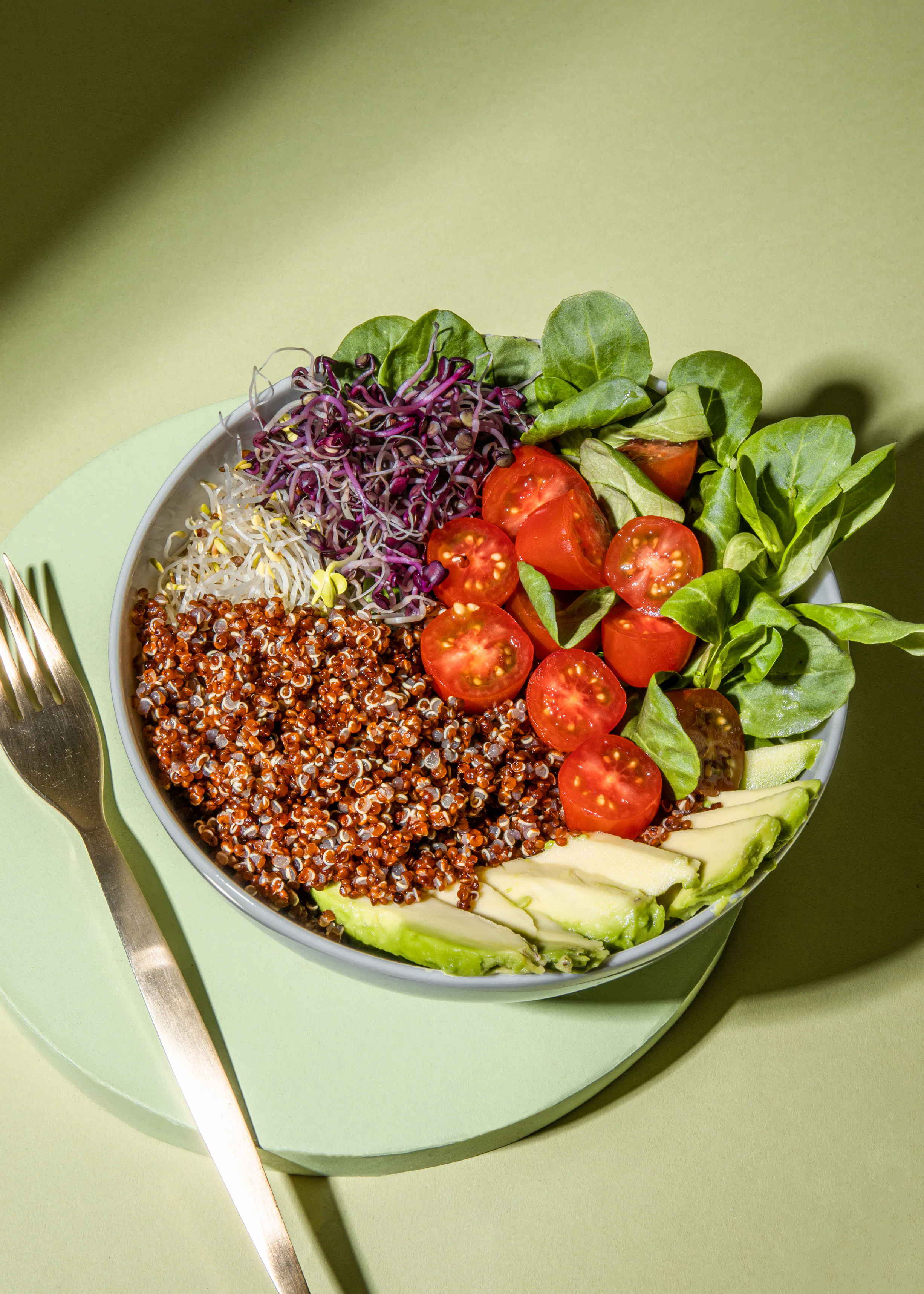 un bol de nourriture avec du quinoa des tomates et de l' avocat avec une fourchette