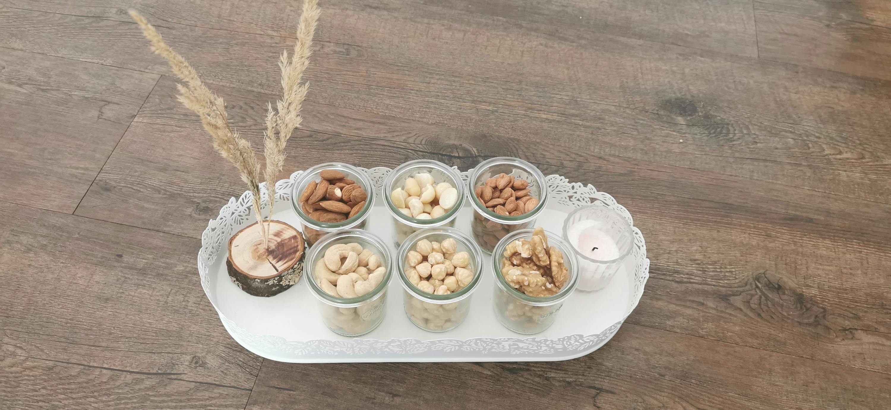 eine Auswahl an Nüssen in Gläsern auf einem Tablett