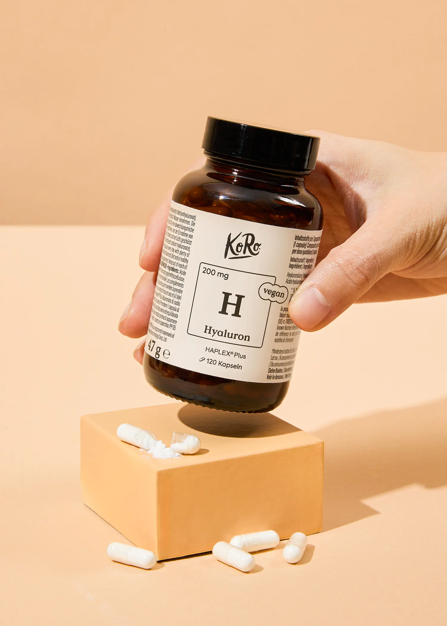 a person is holding a bottle of hyaluron capsules