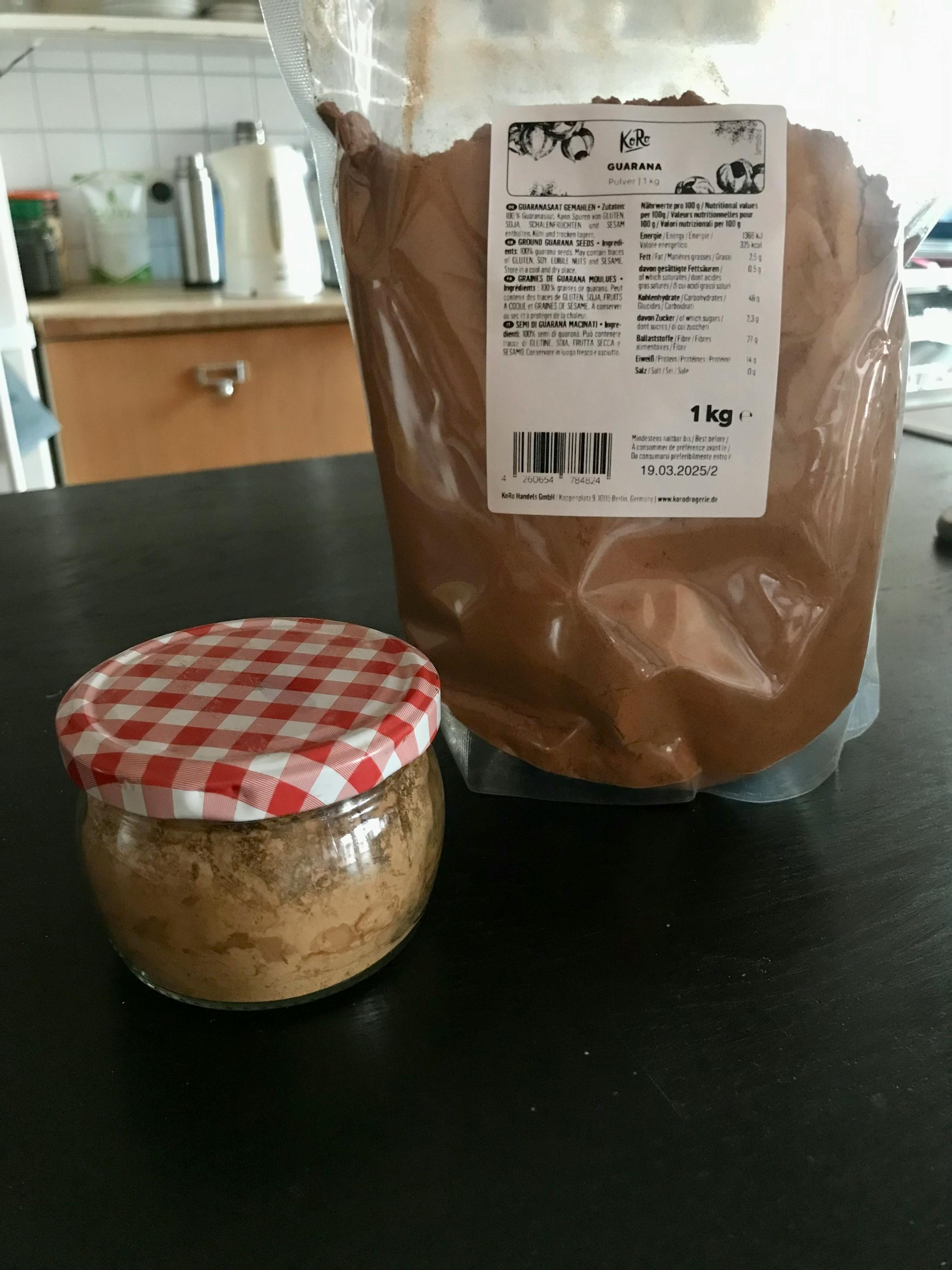 ein Glas und eine Tüte kakaopulver auf einem Tisch