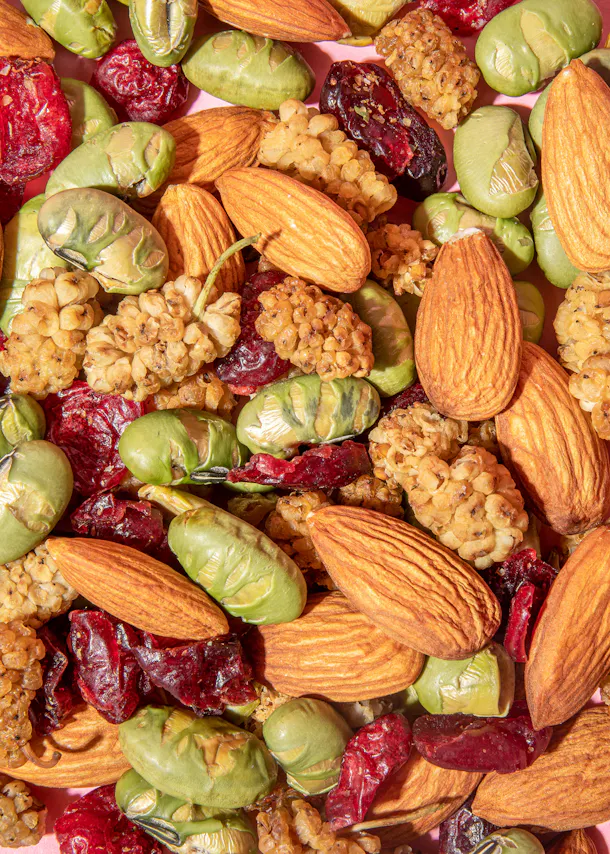 un tas de noix et de baies sur un fond rose