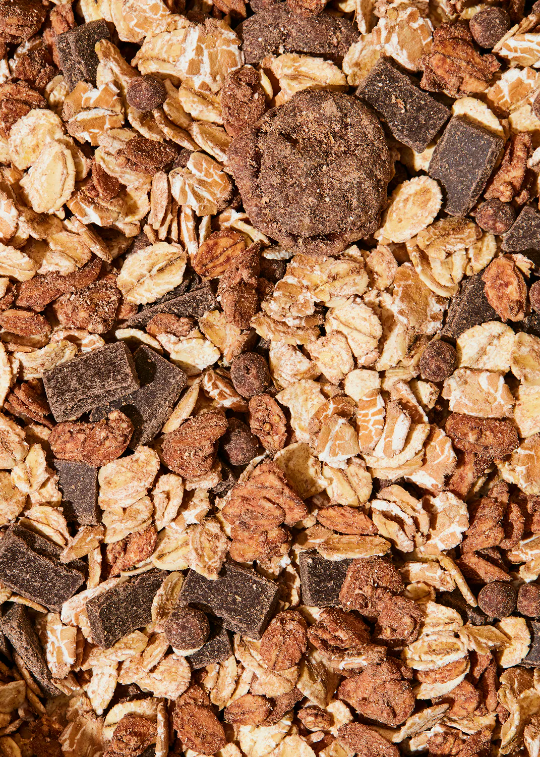 un gros plan d' un tas de flocons d' avoine avec des morceaux de chocolat