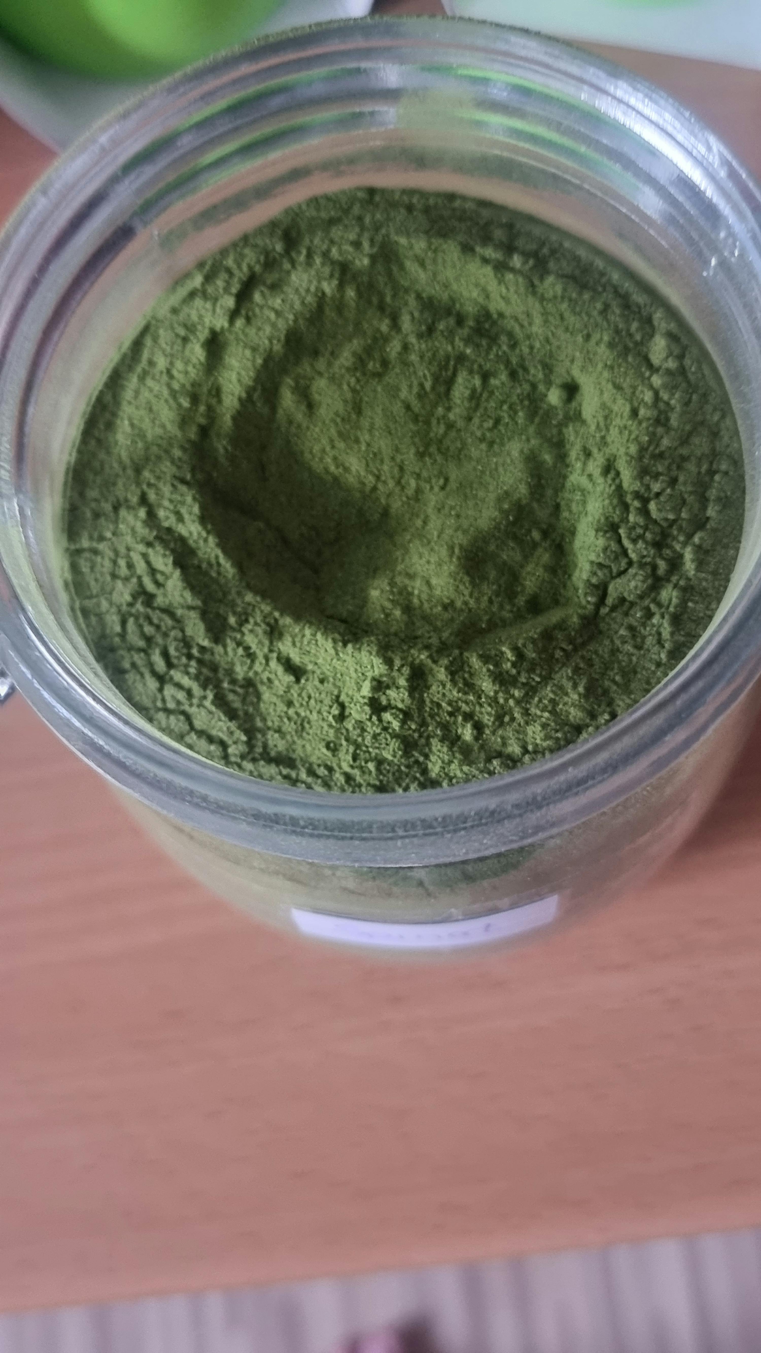 a jar of green powder sits on a table