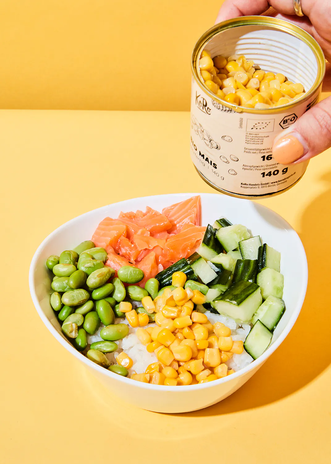 a can of corn is being poured into a bowl of food