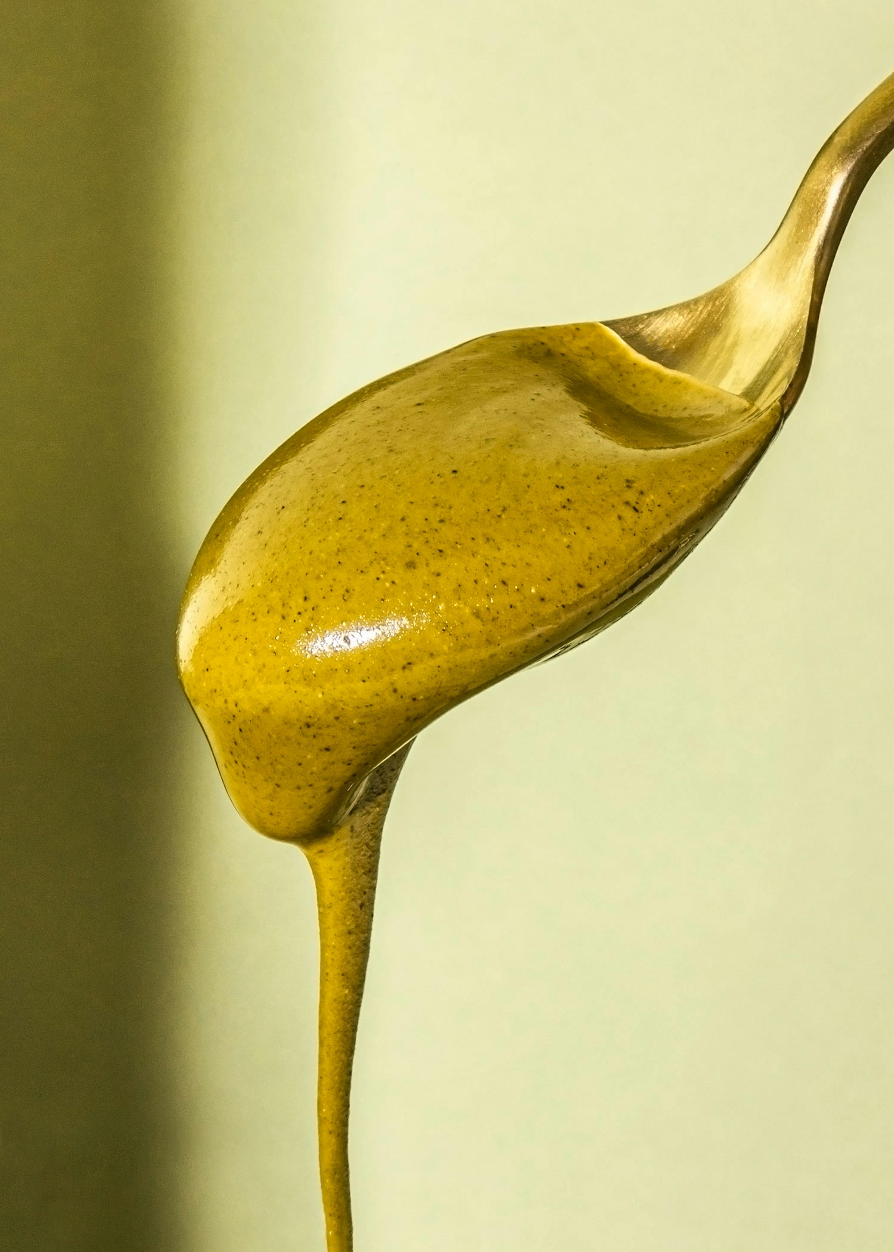 a close up of a spoon filled with yellow liquid