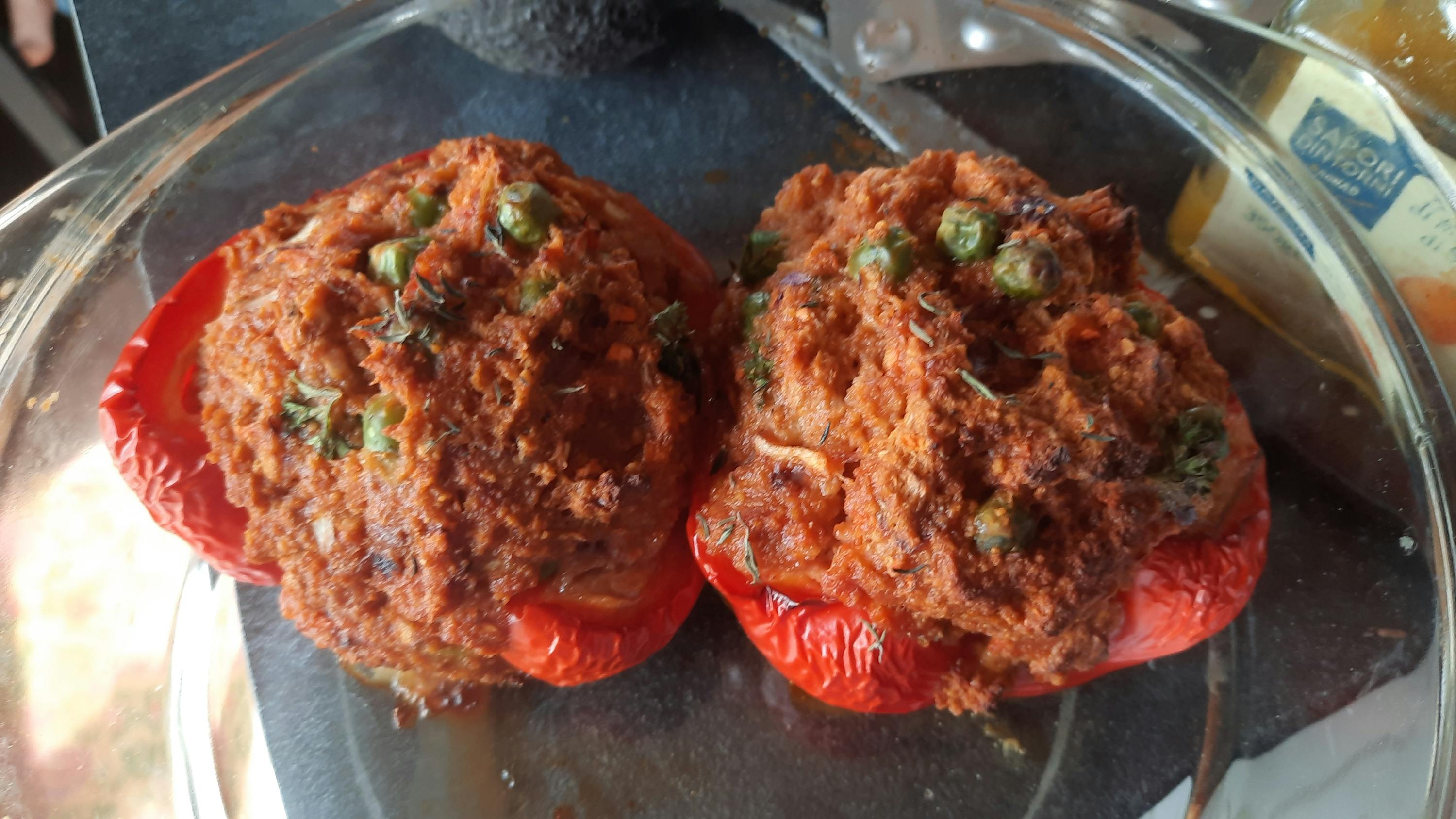 zwei gefüllte Tomaten sitzen auf einem Teller mit einem Etikett darauf
