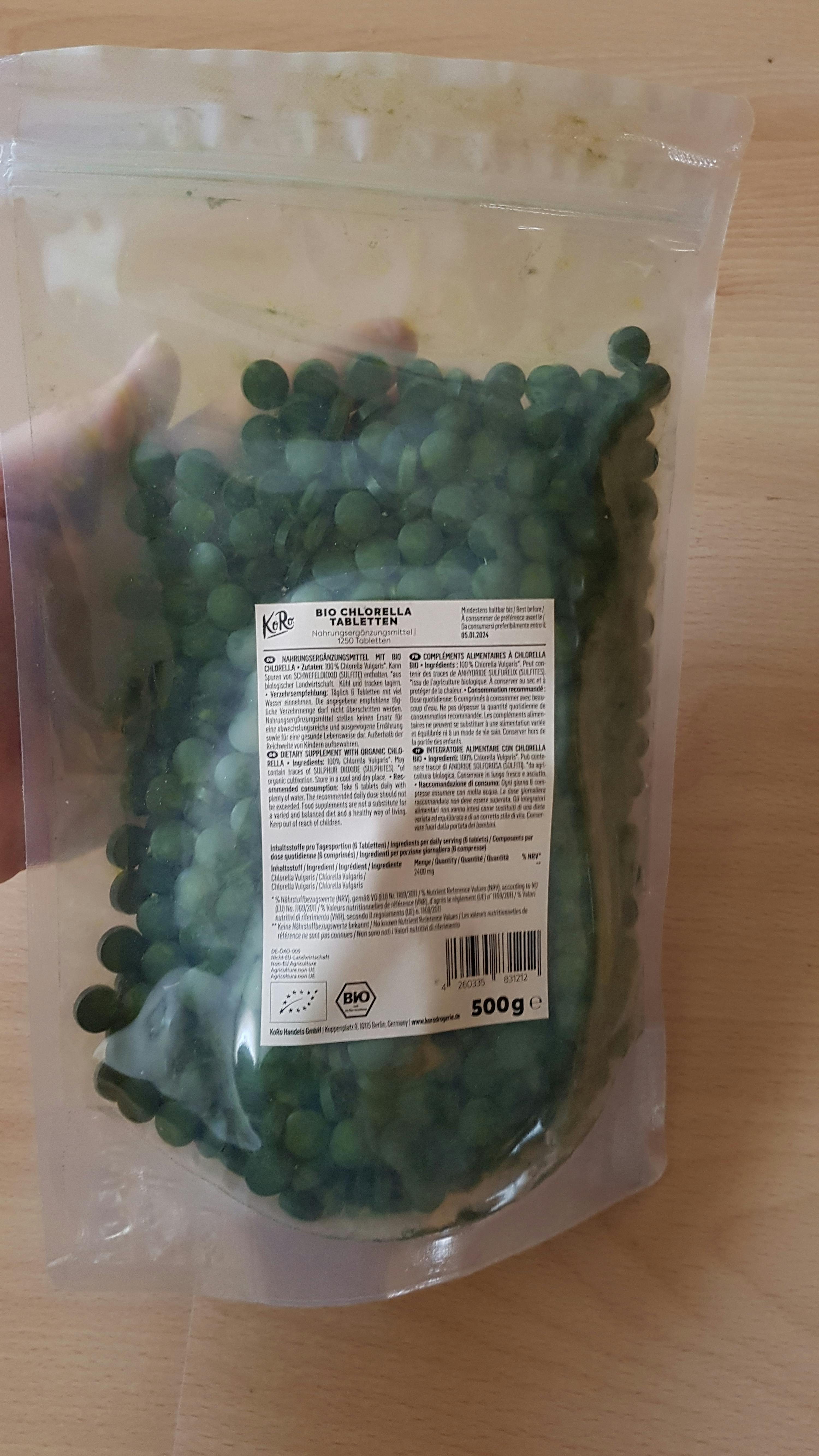 une personne tient un sac en plastique rempli de haricots verts