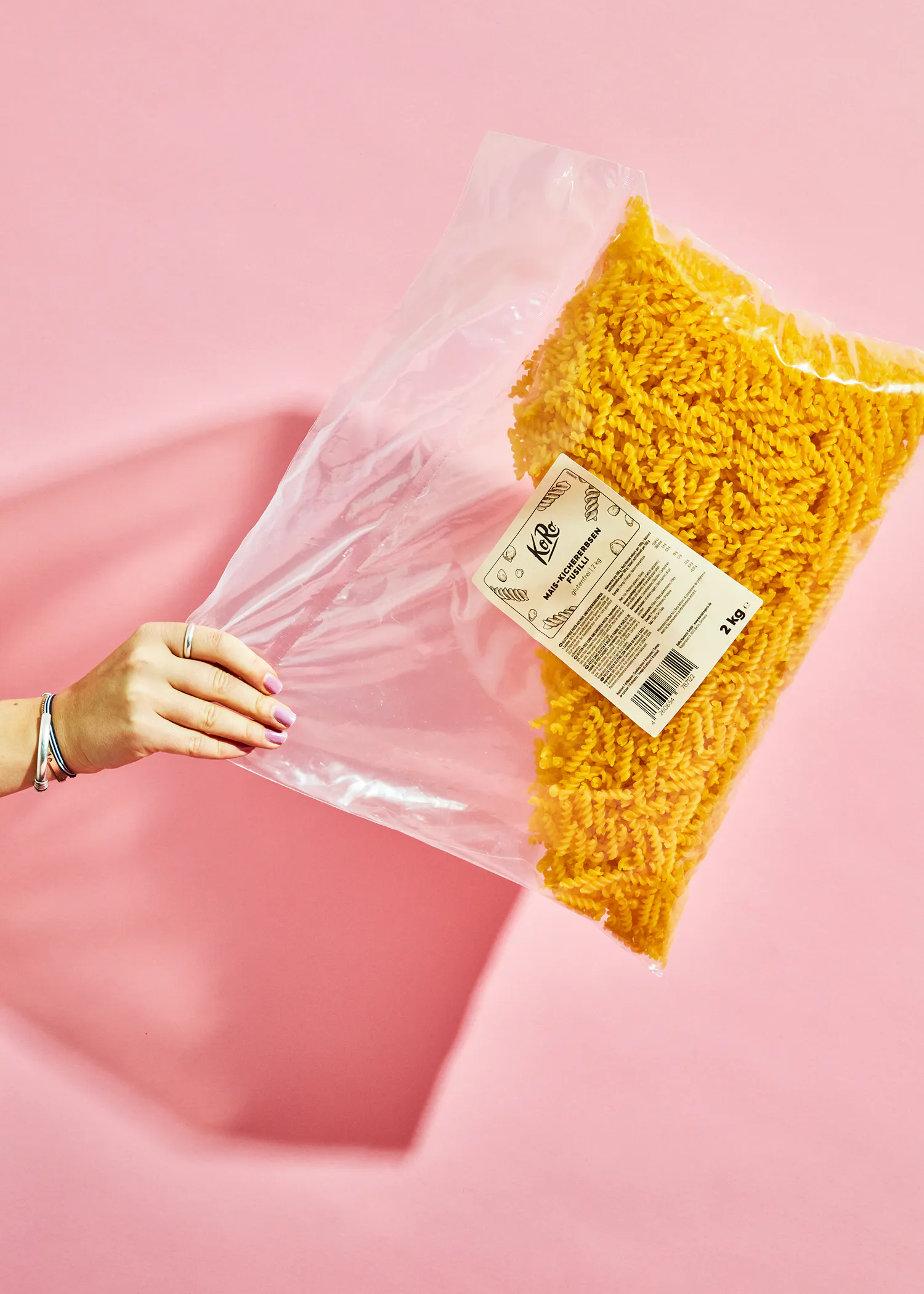 a person is holding a bag of pasta with a label that says 1 kg