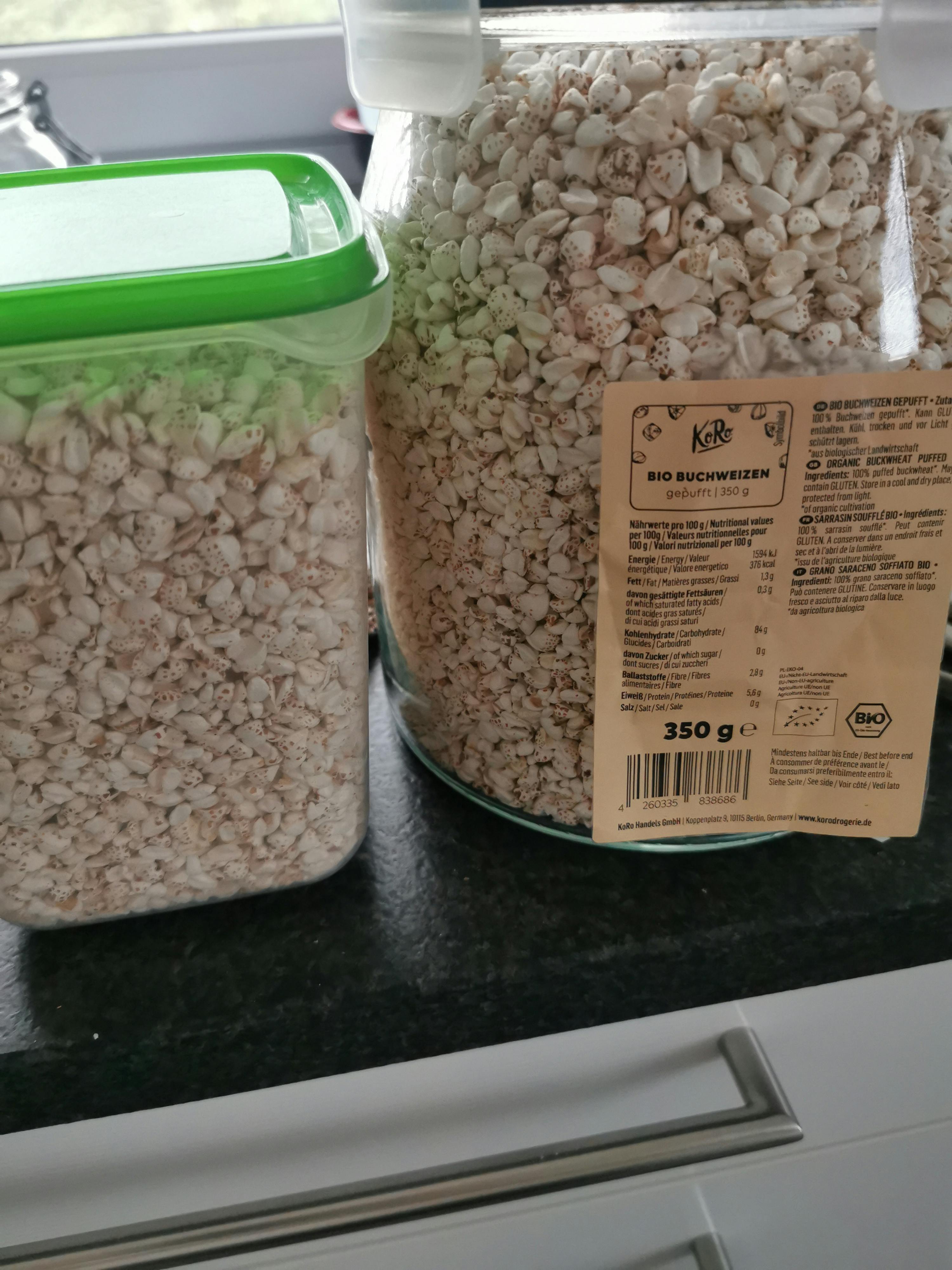 un barattolo di cereali bio è accanto a un contenitore di cereali bio