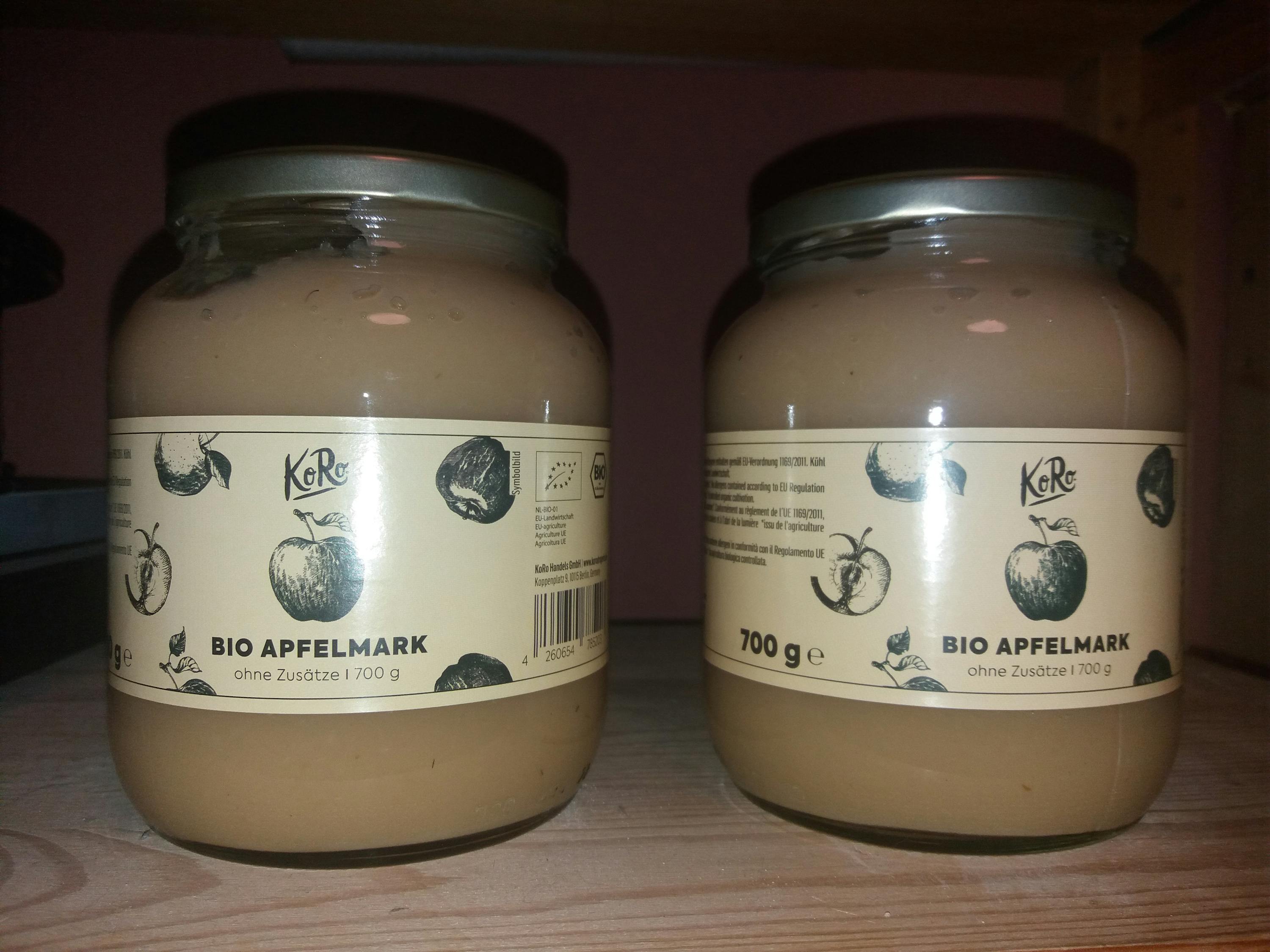 due barattoli di kere bio apfelmark sono seduti uno accanto all'altro su un tavolo di legno