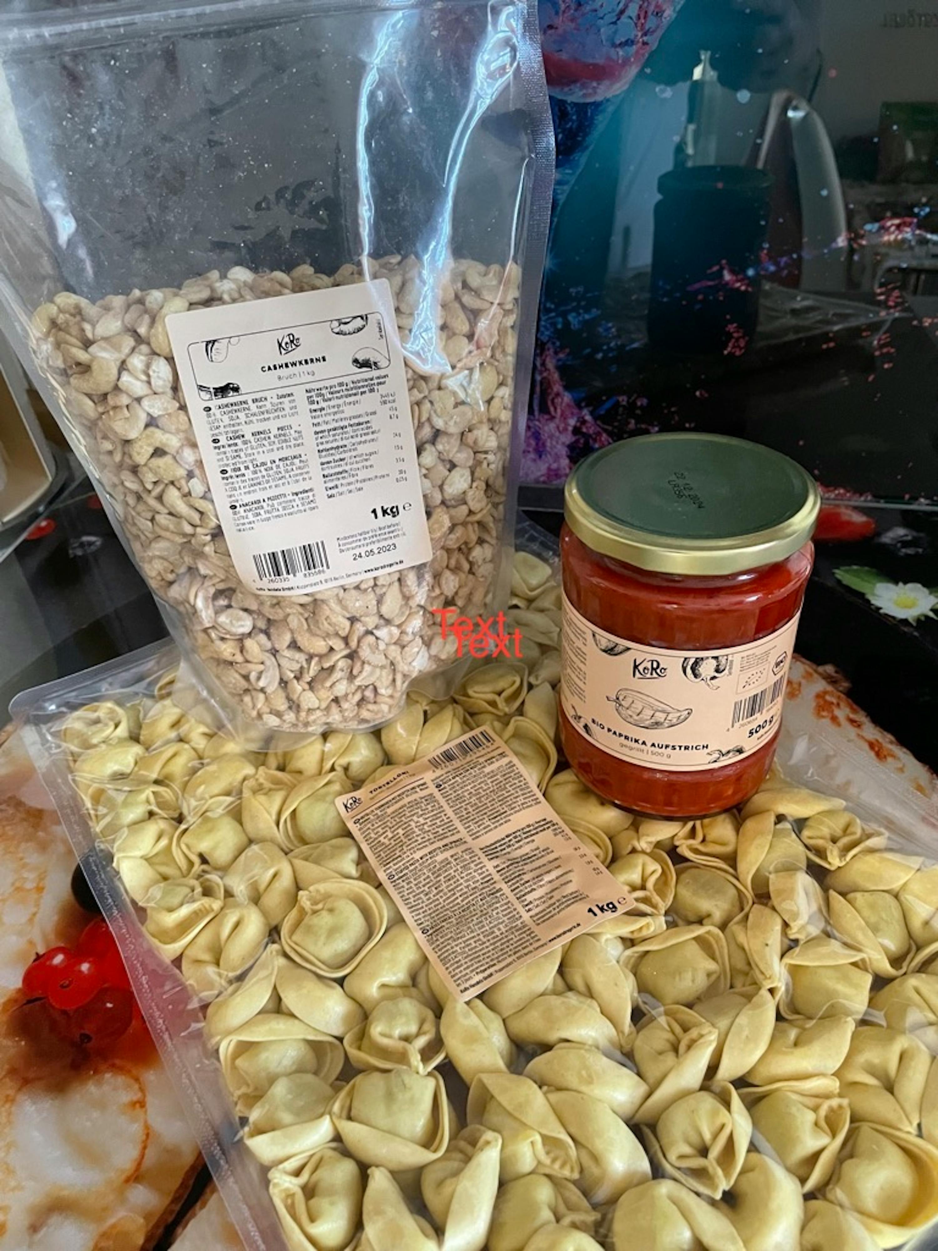 Eine Tüte Nudeln steht neben einem Glas Tomatensoße