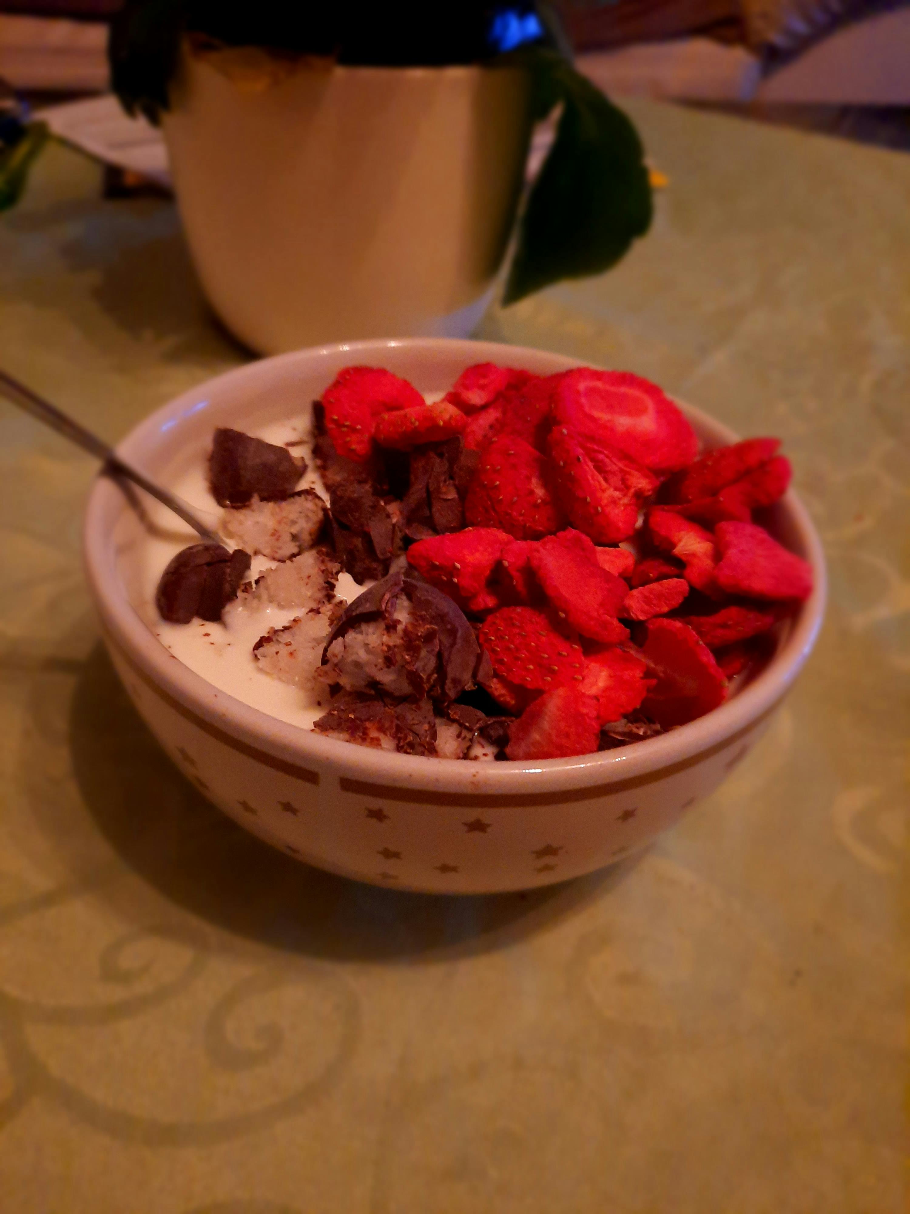 a bowl of strawberries and chocolate chips on a table