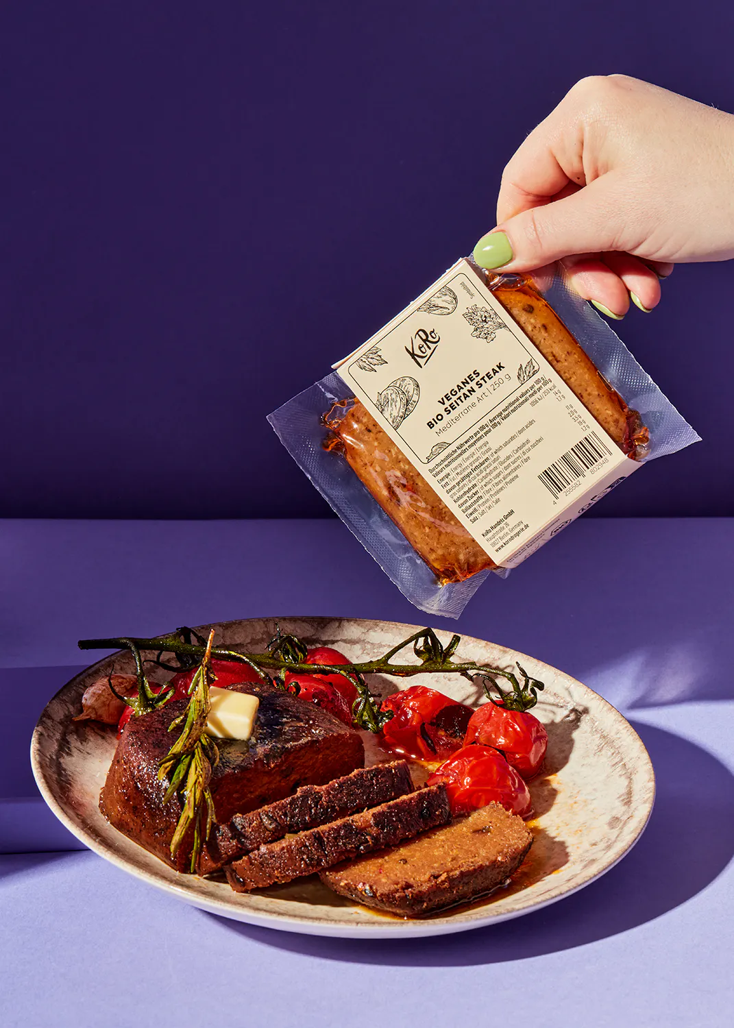 eine Person hält einen Plastikbeutel mit einem veganen Rindfleischsteak darauf