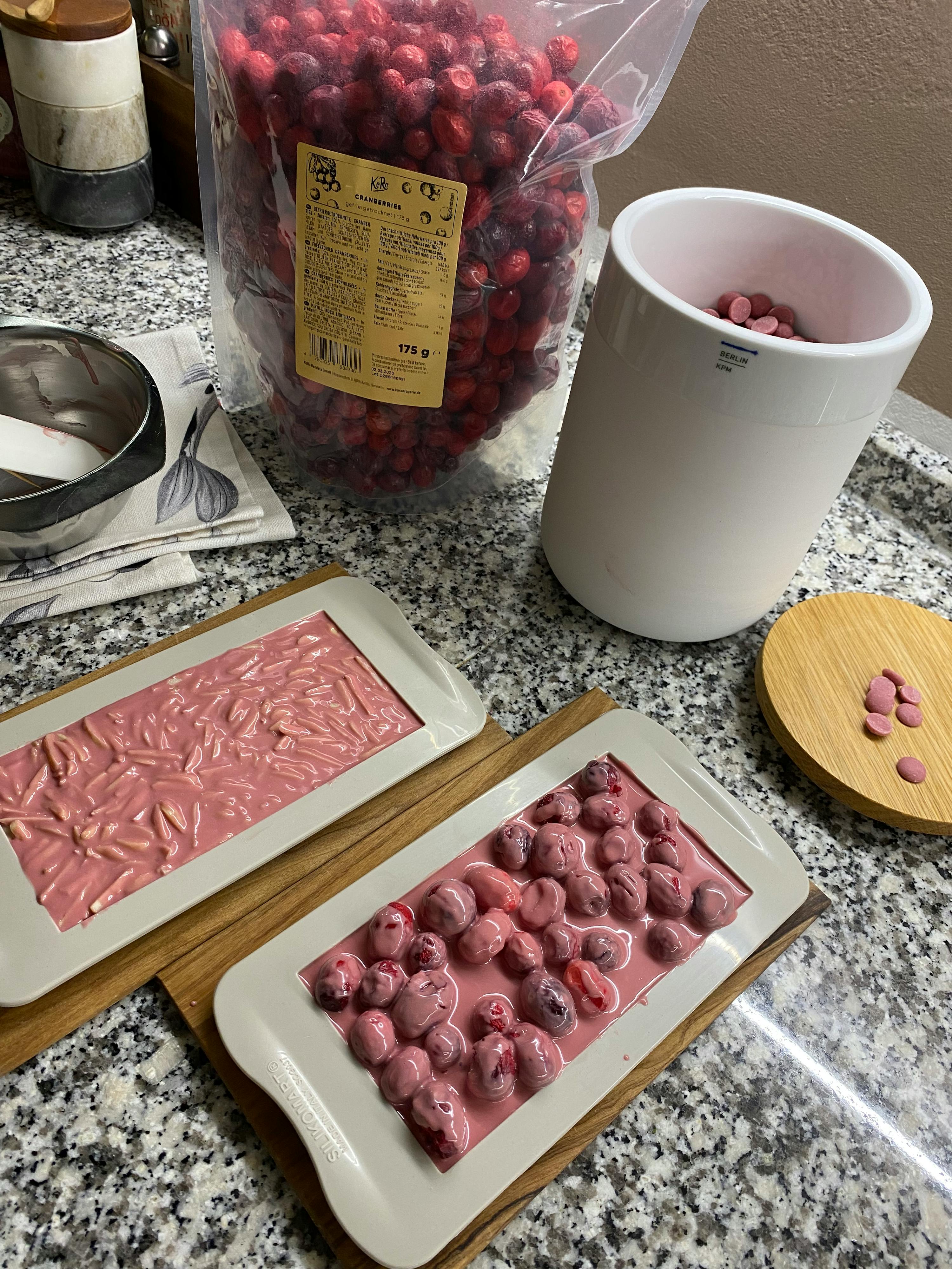 ein weißes Tablett mit Kirschen darauf steht neben einem Plastikbeutel mit Kirschen