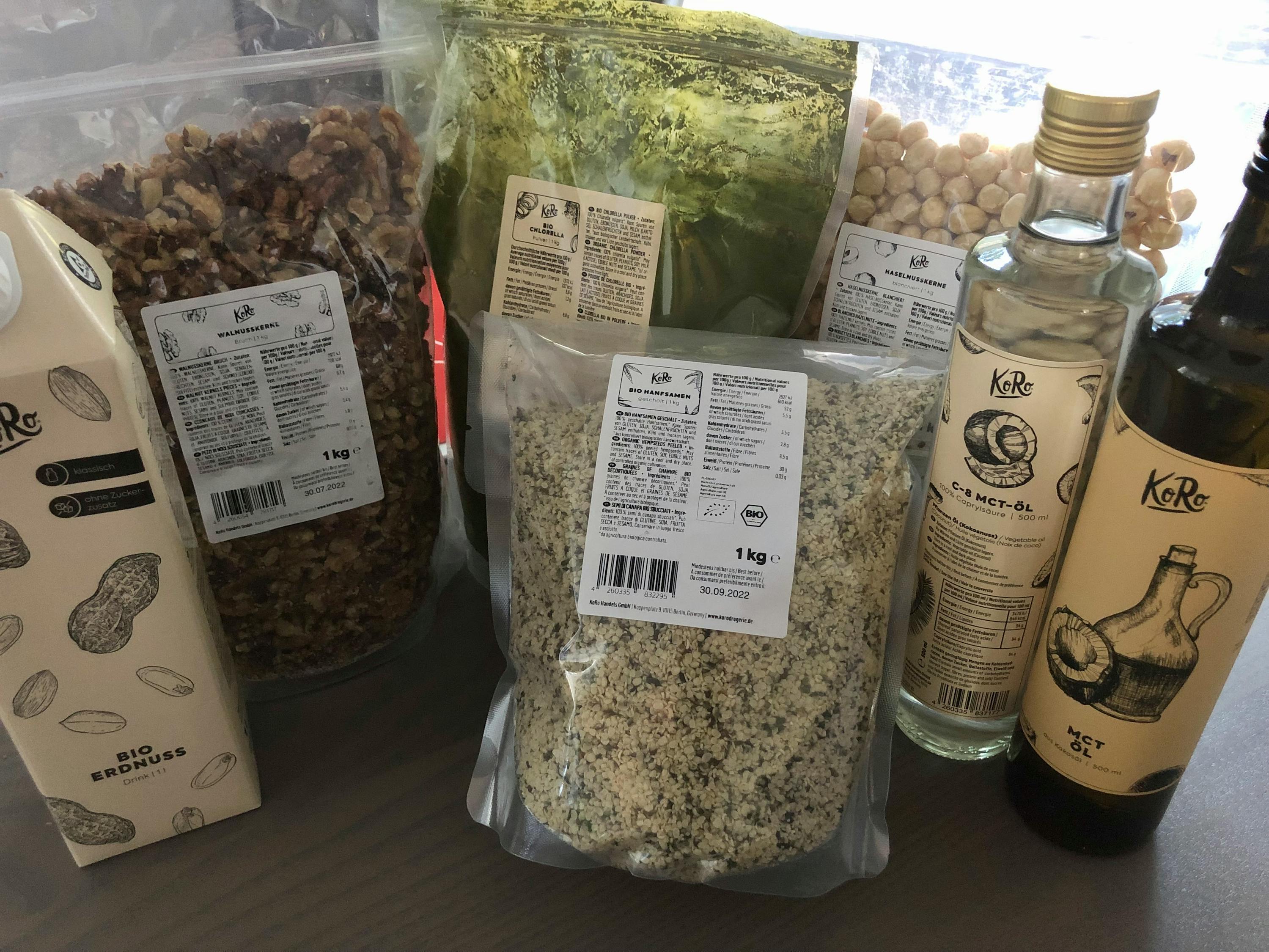 a bottle of koko oil sits next to a bag of nuts