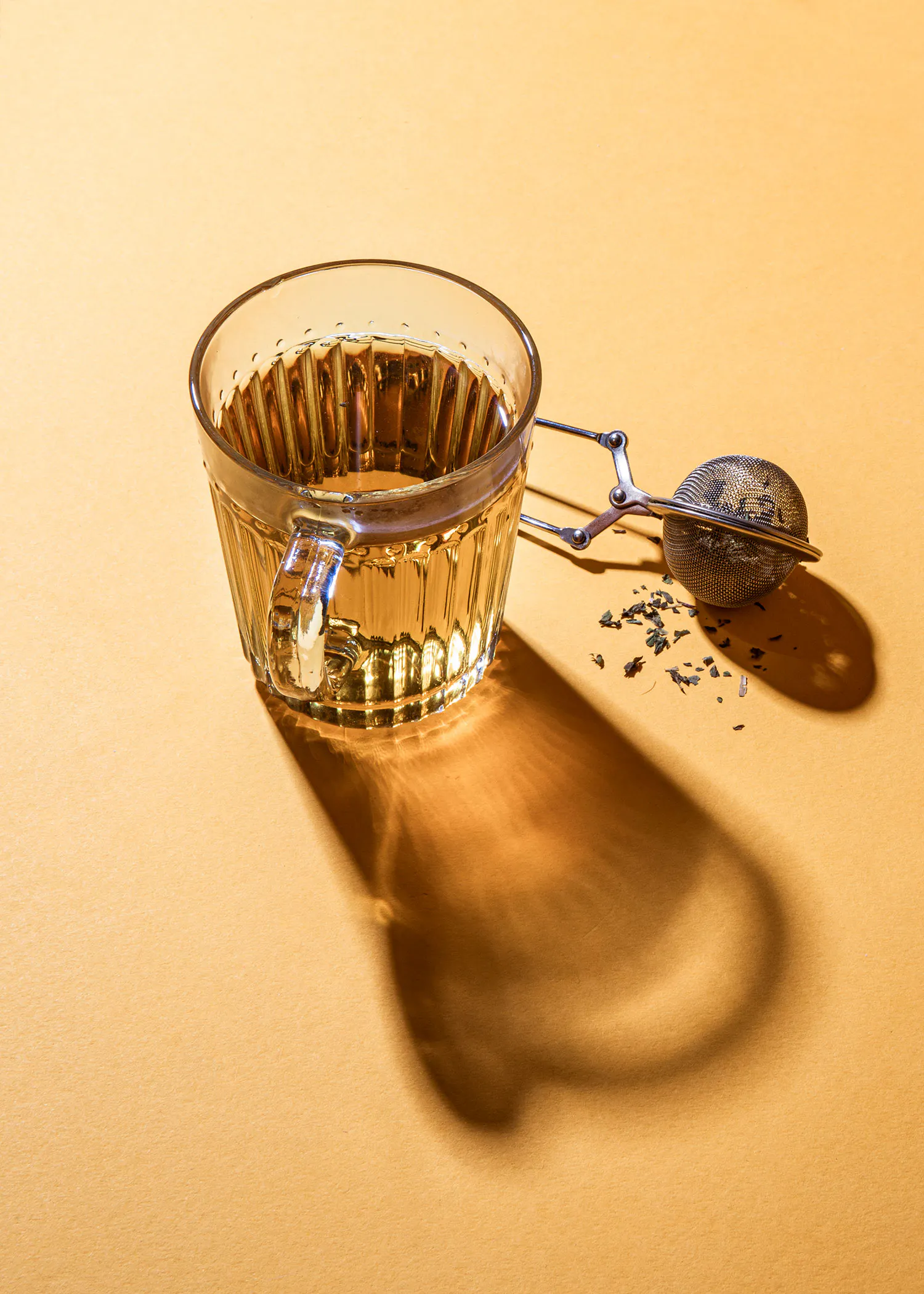 eine Tasse Tee mit einem Teefilter neben ihr